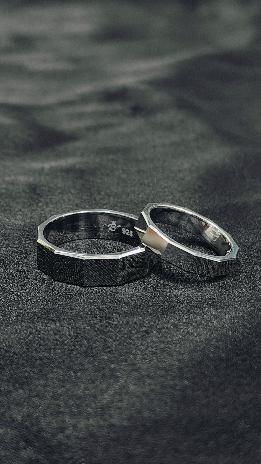 Two silver rings on a textured black surface