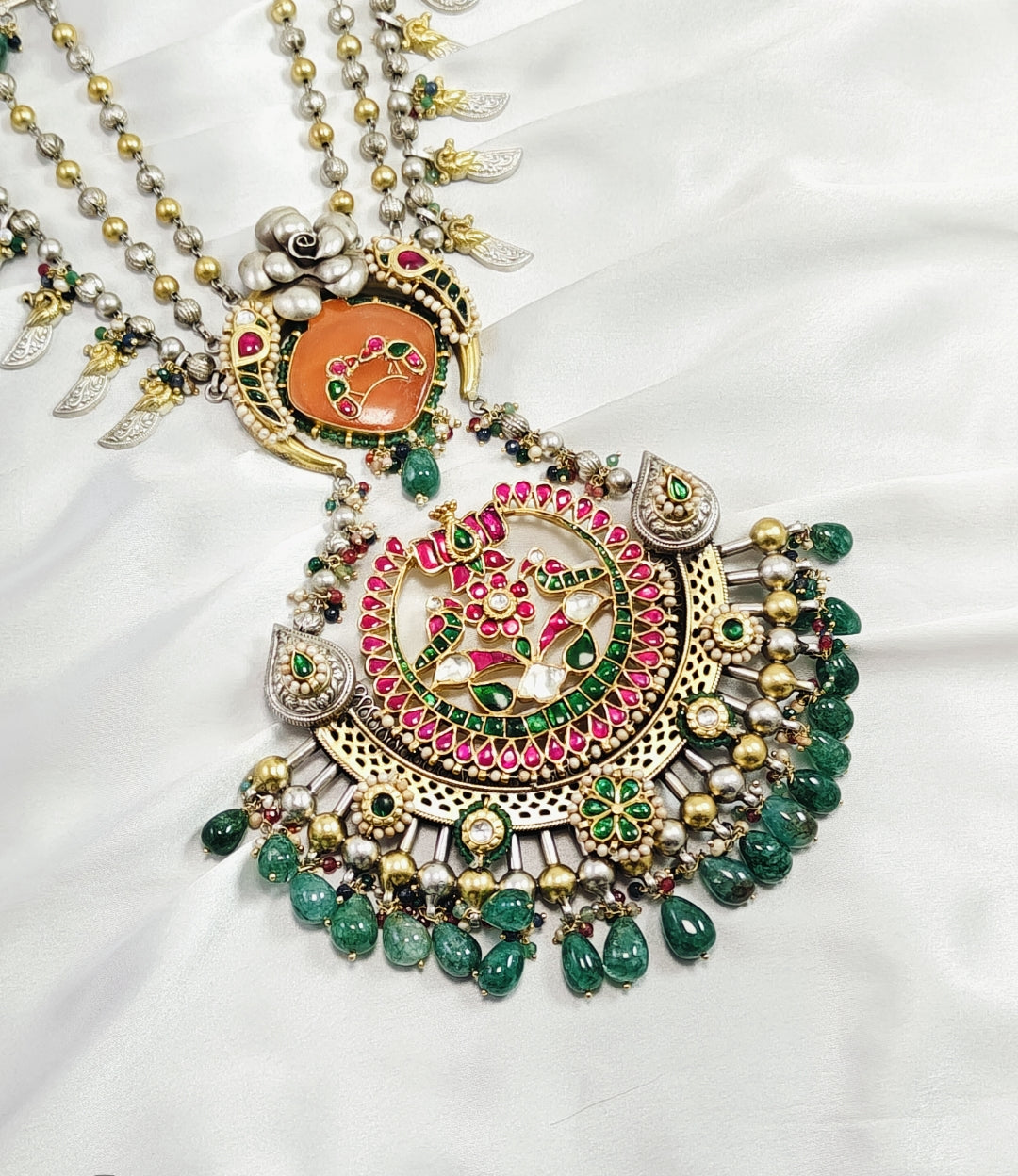 Decorative necklace with green beads and intricate design on a white background