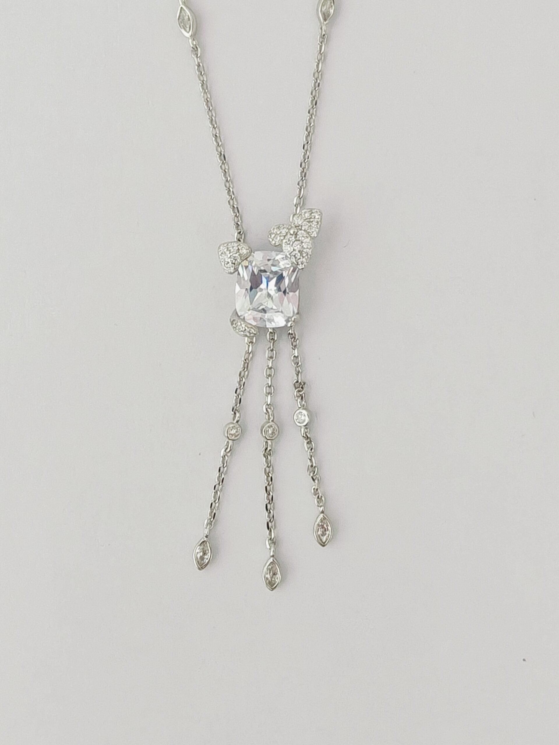 Silver necklace with a central gemstone on a light gray background