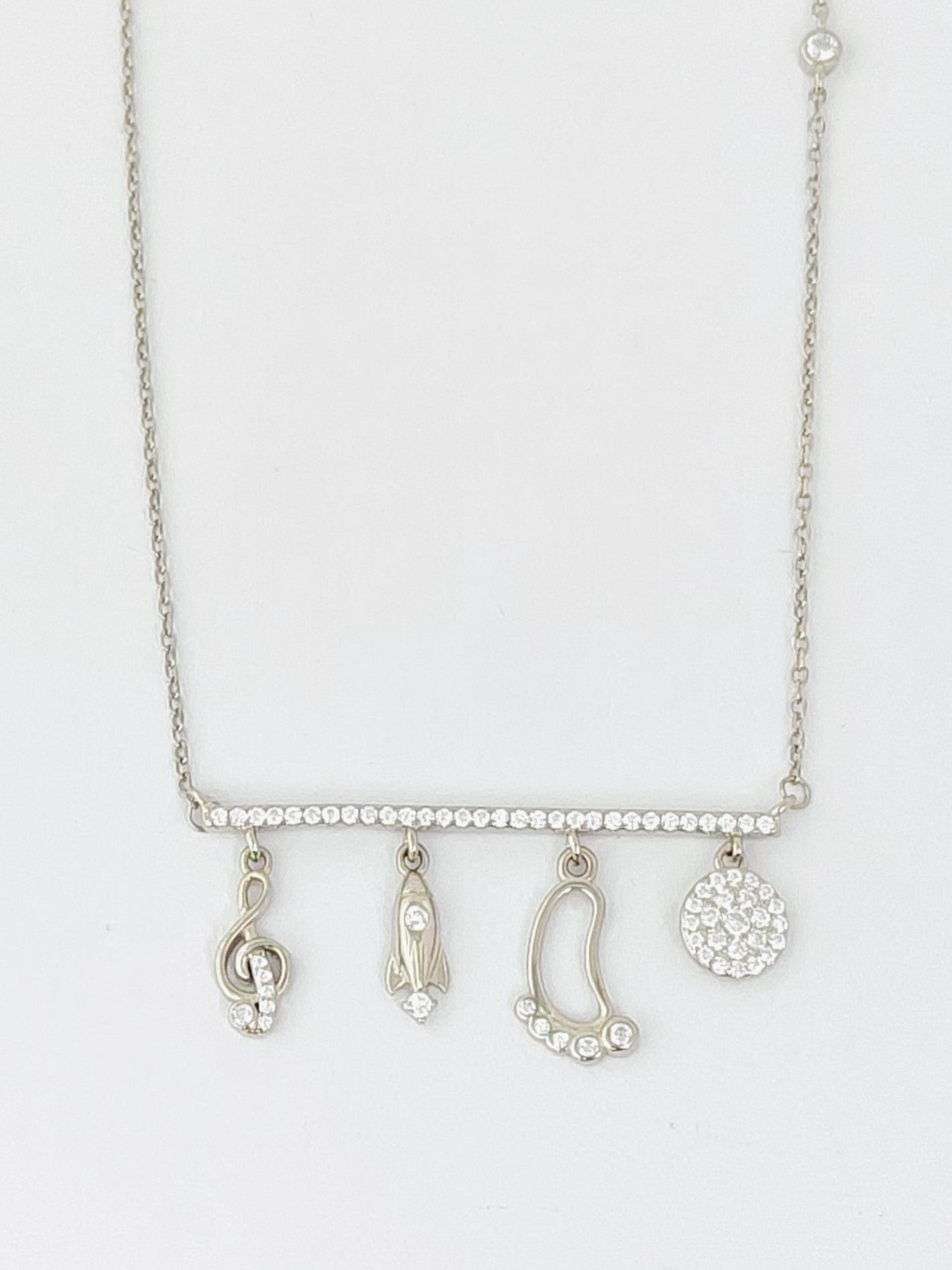 Silver necklace with various pendants on a white background