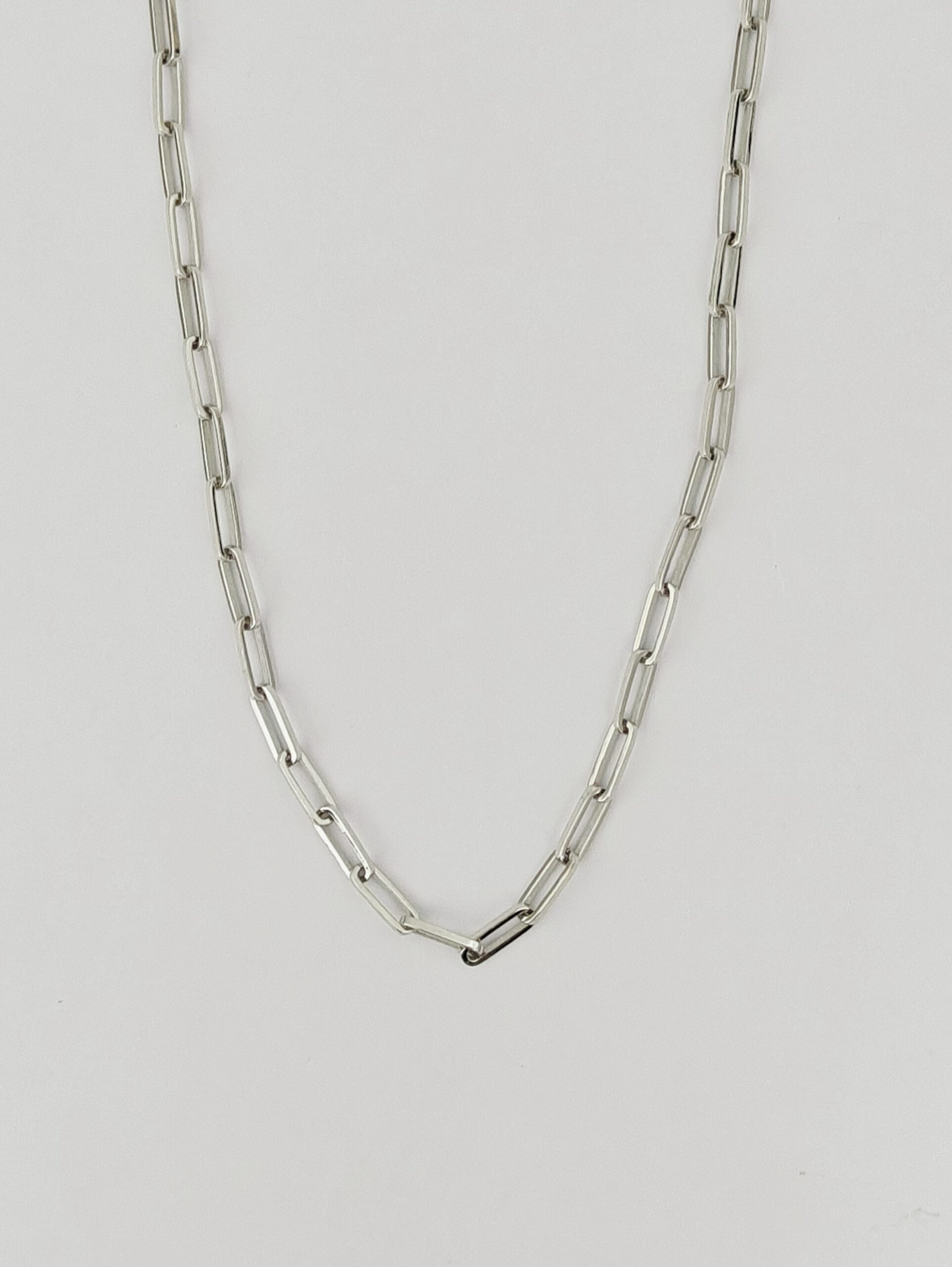 Silver chain necklace on a light gray background