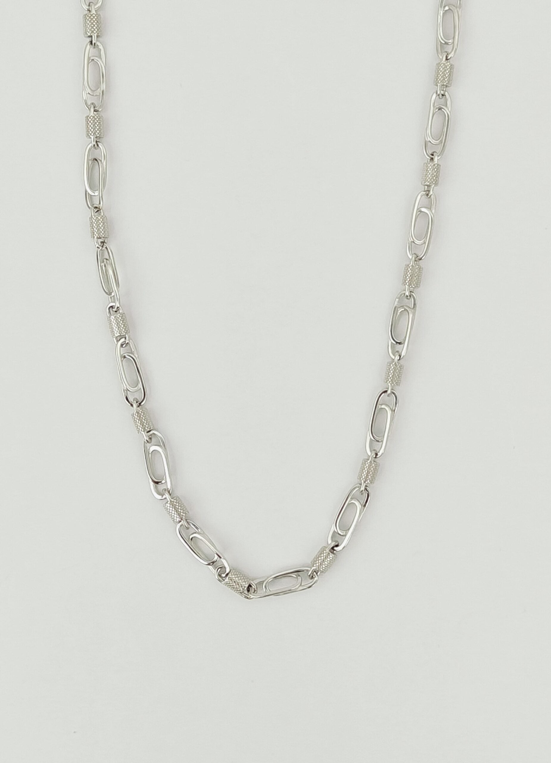 Silver chain necklace on a light gray background