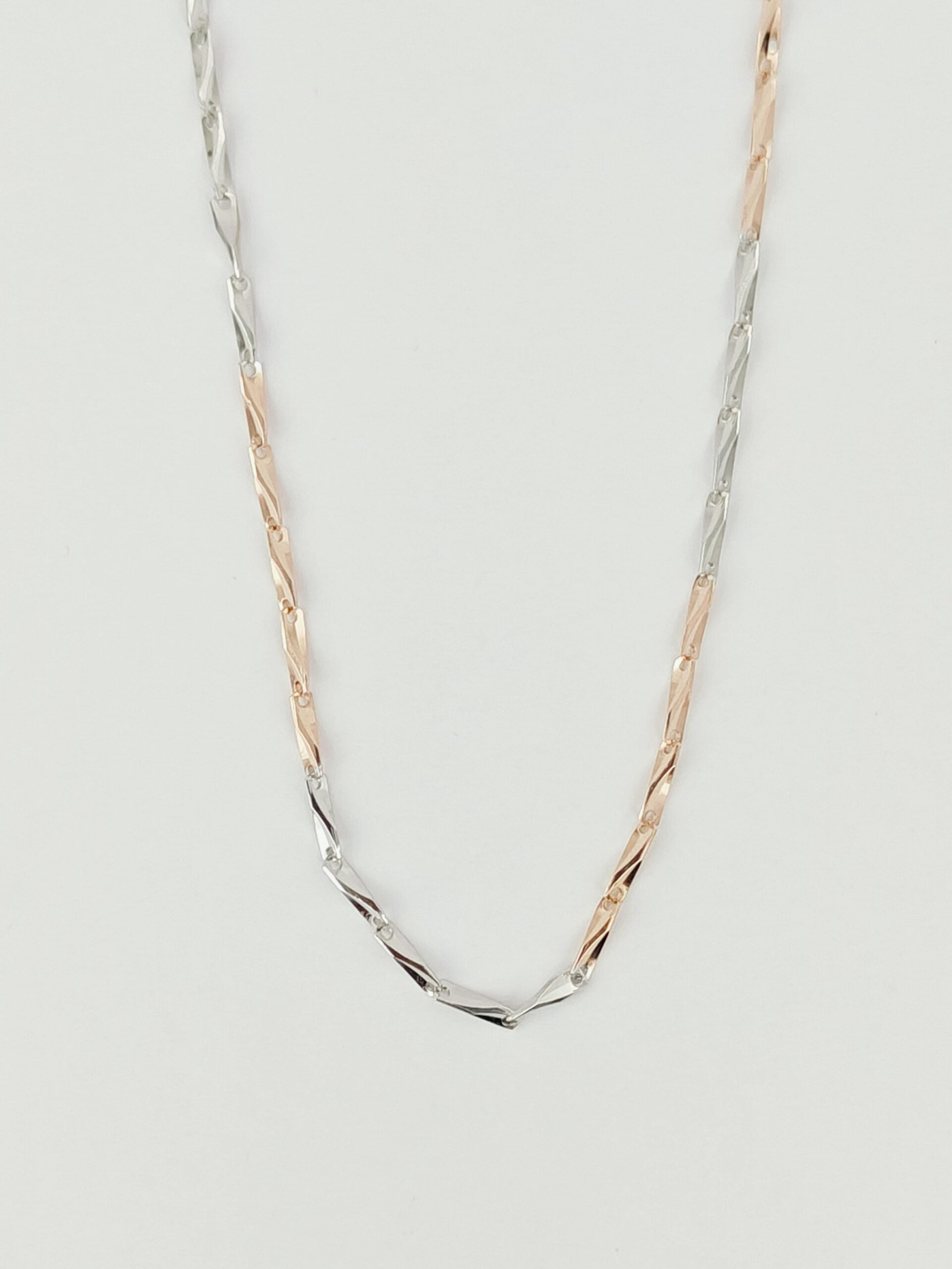 Two gold and silver necklaces on a light gray background