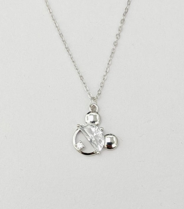 Silver necklace with a clear pendant on a light gray background