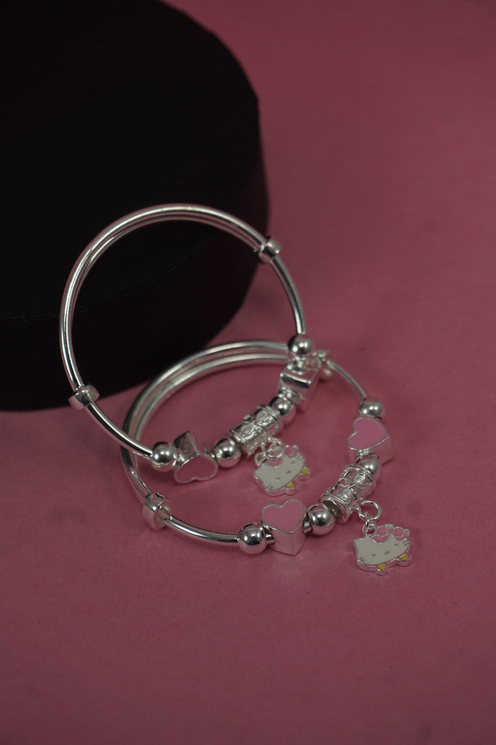 Silver bracelet with charms on a pink background