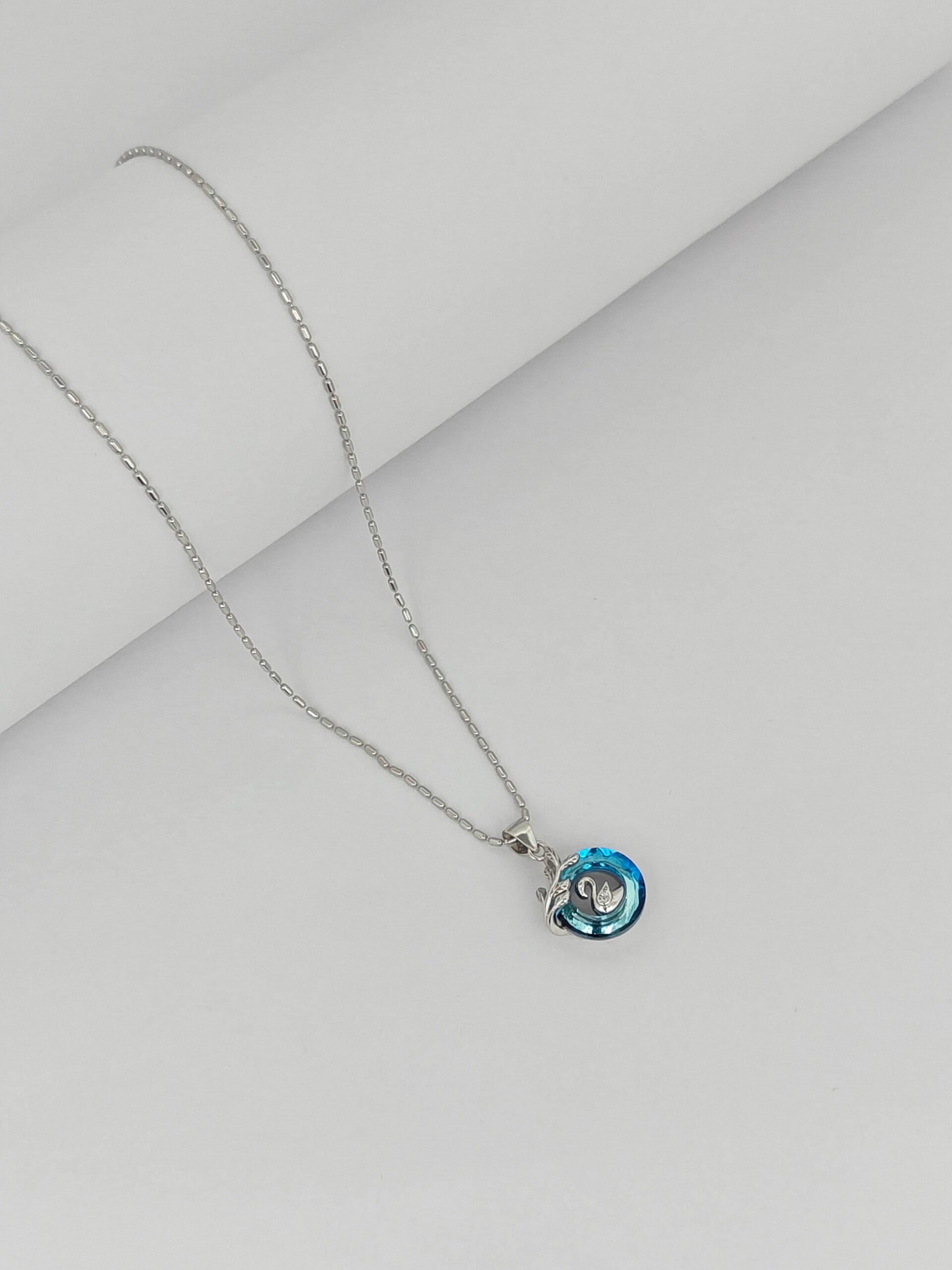 Necklace with a blue pendant on a light gray background