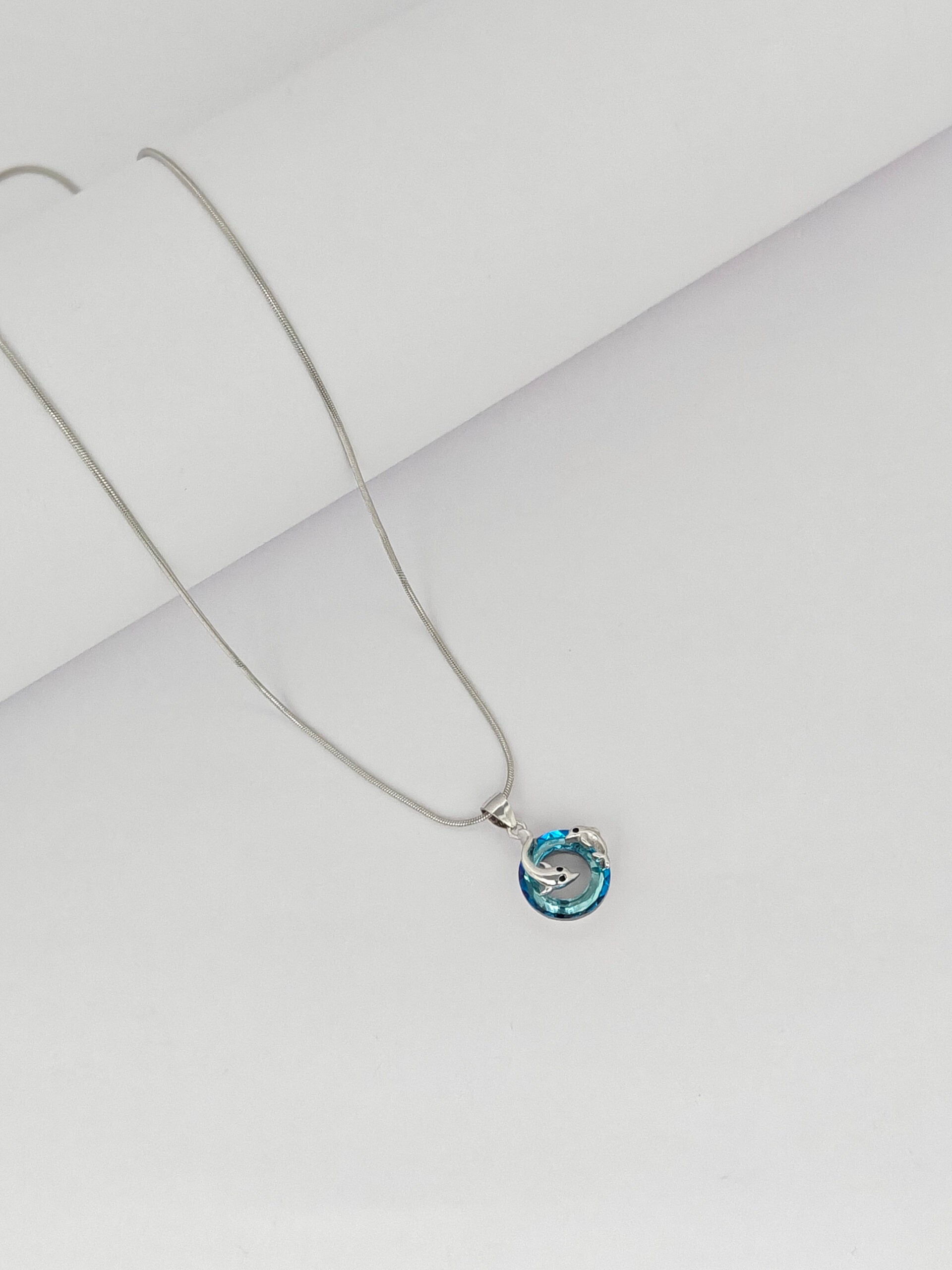 Necklace with a blue pendant on a light gray background