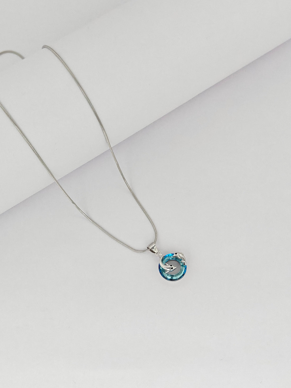 Necklace with a blue pendant on a light gray background