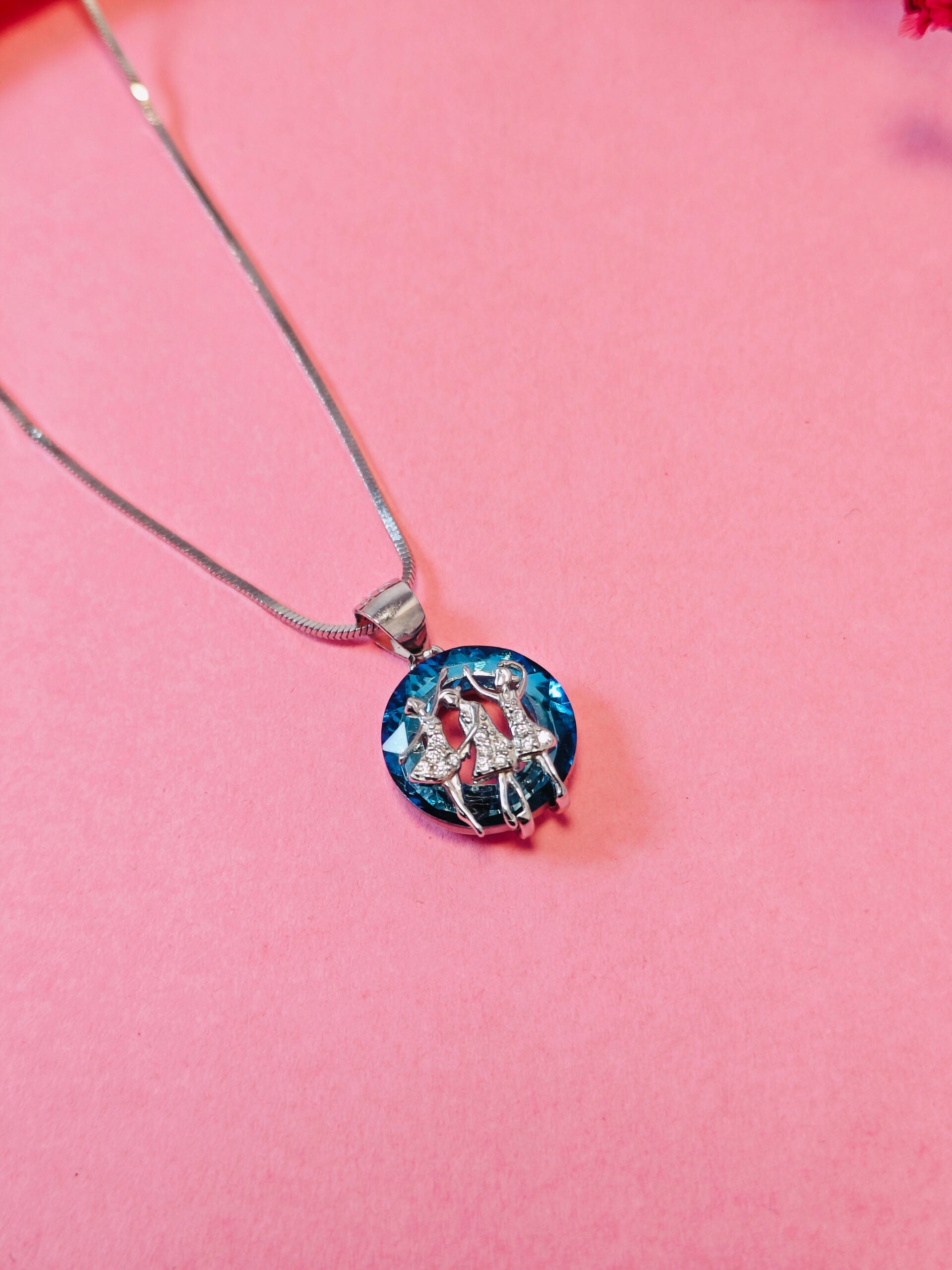 Necklace with a decorative pendant on a pink background