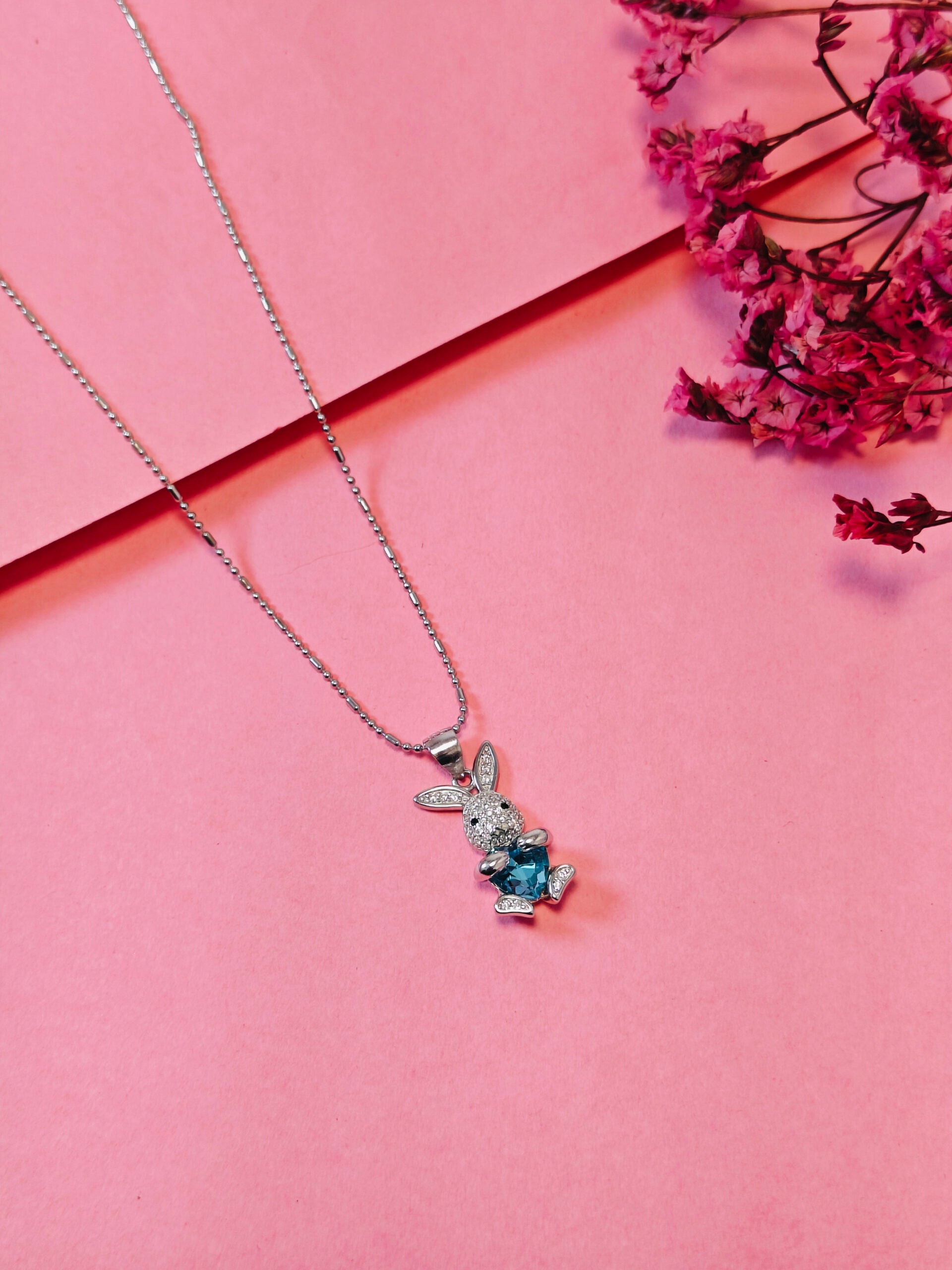 Necklace with a bunny pendant on a pink background
