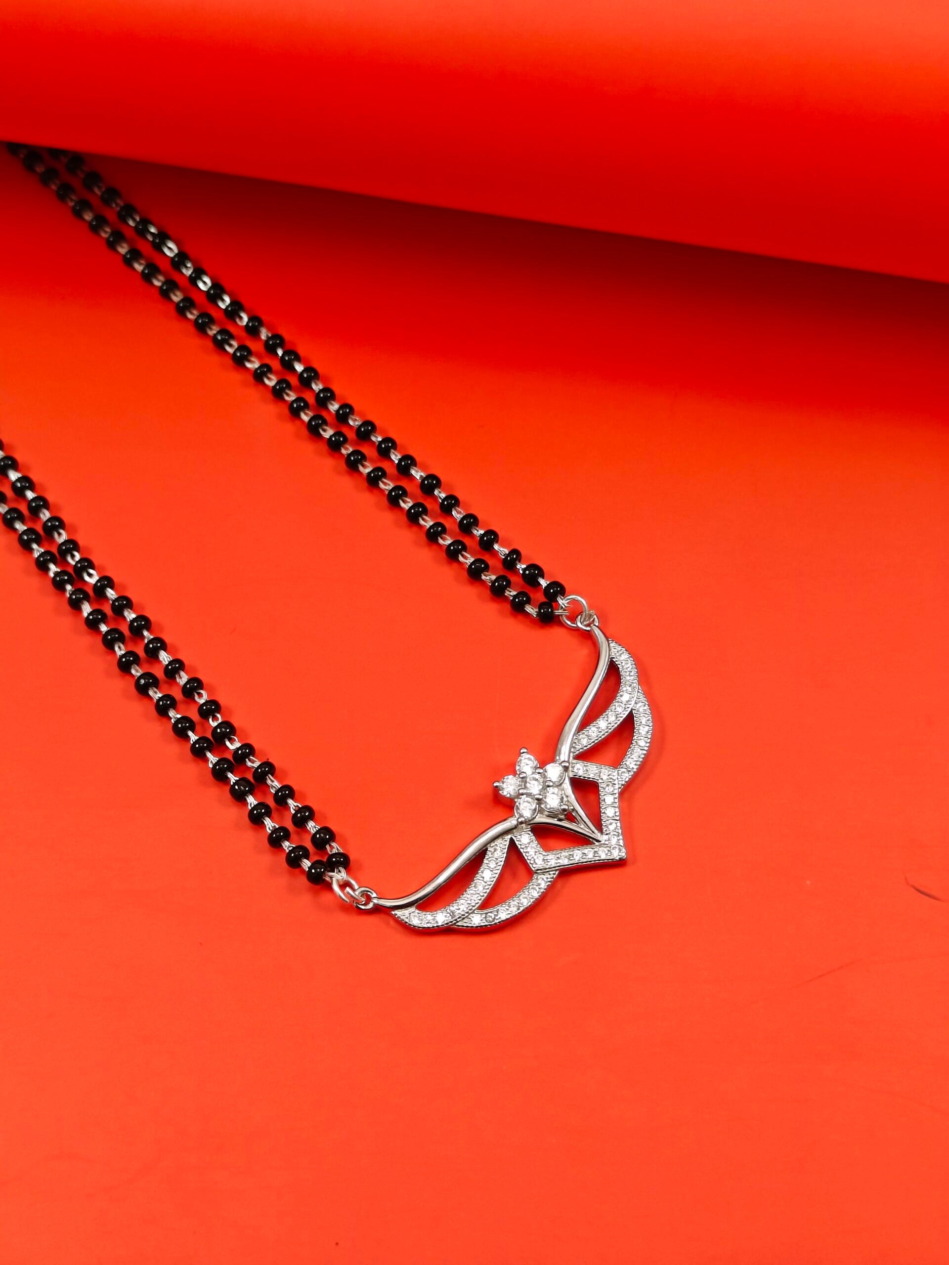 Silver necklace with a floral design on a red background