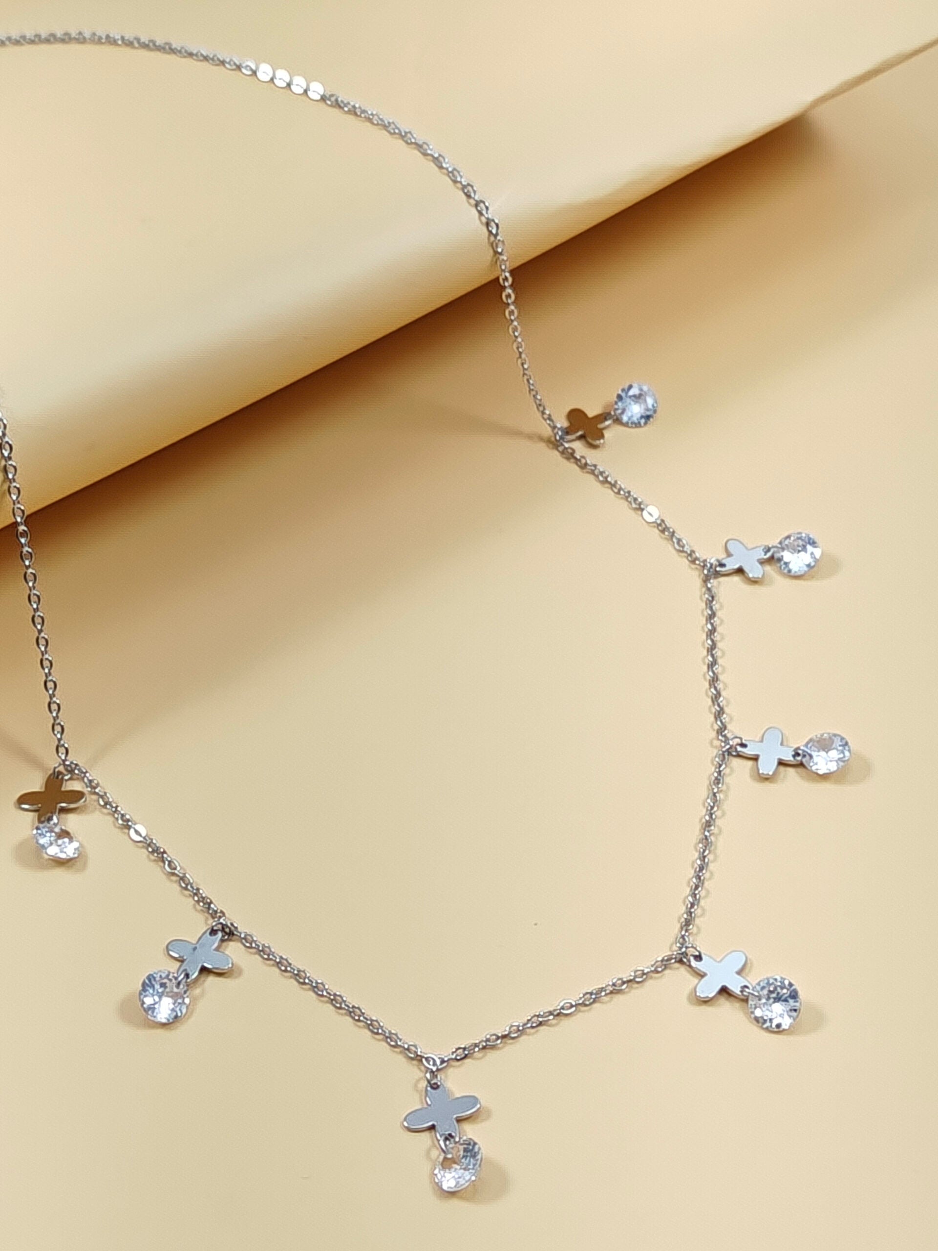 Necklace with star and heart pendants on a beige background