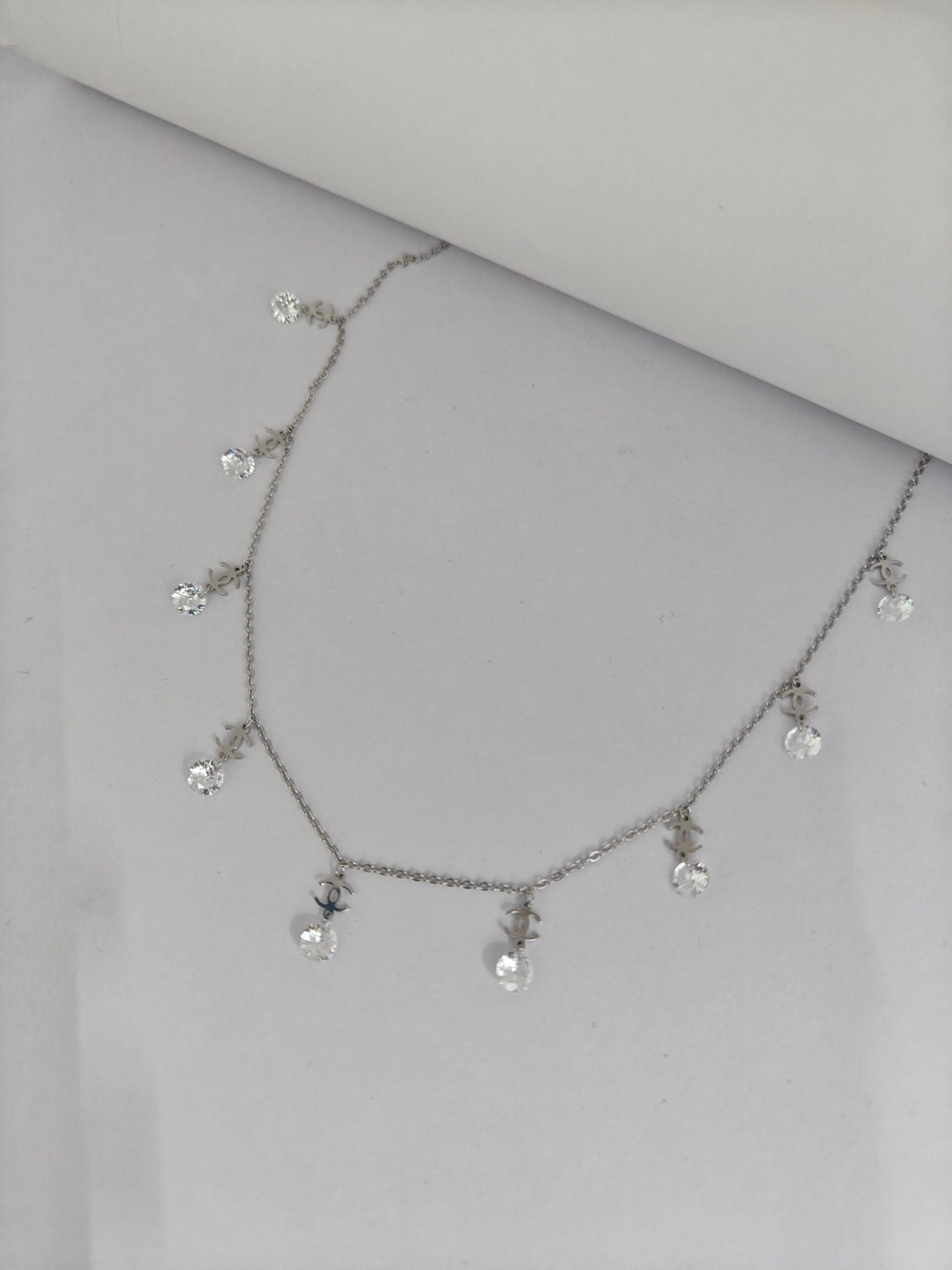 Necklace with small crystals on a light gray background