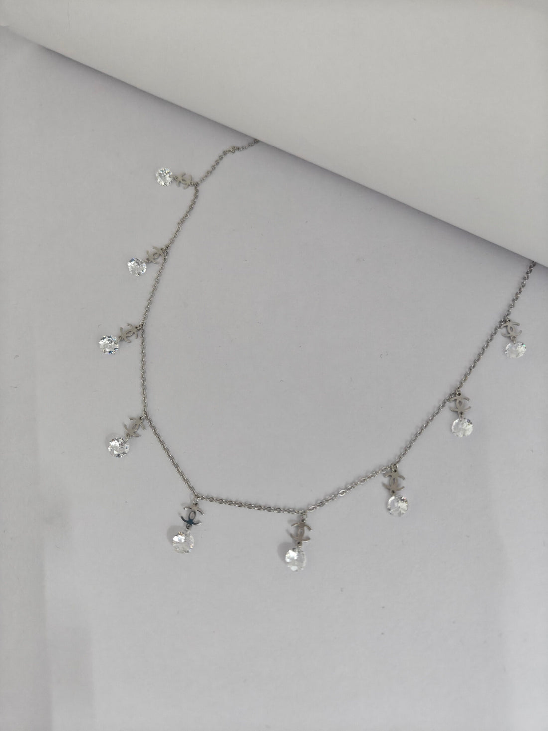 Necklace with small crystals on a light gray background