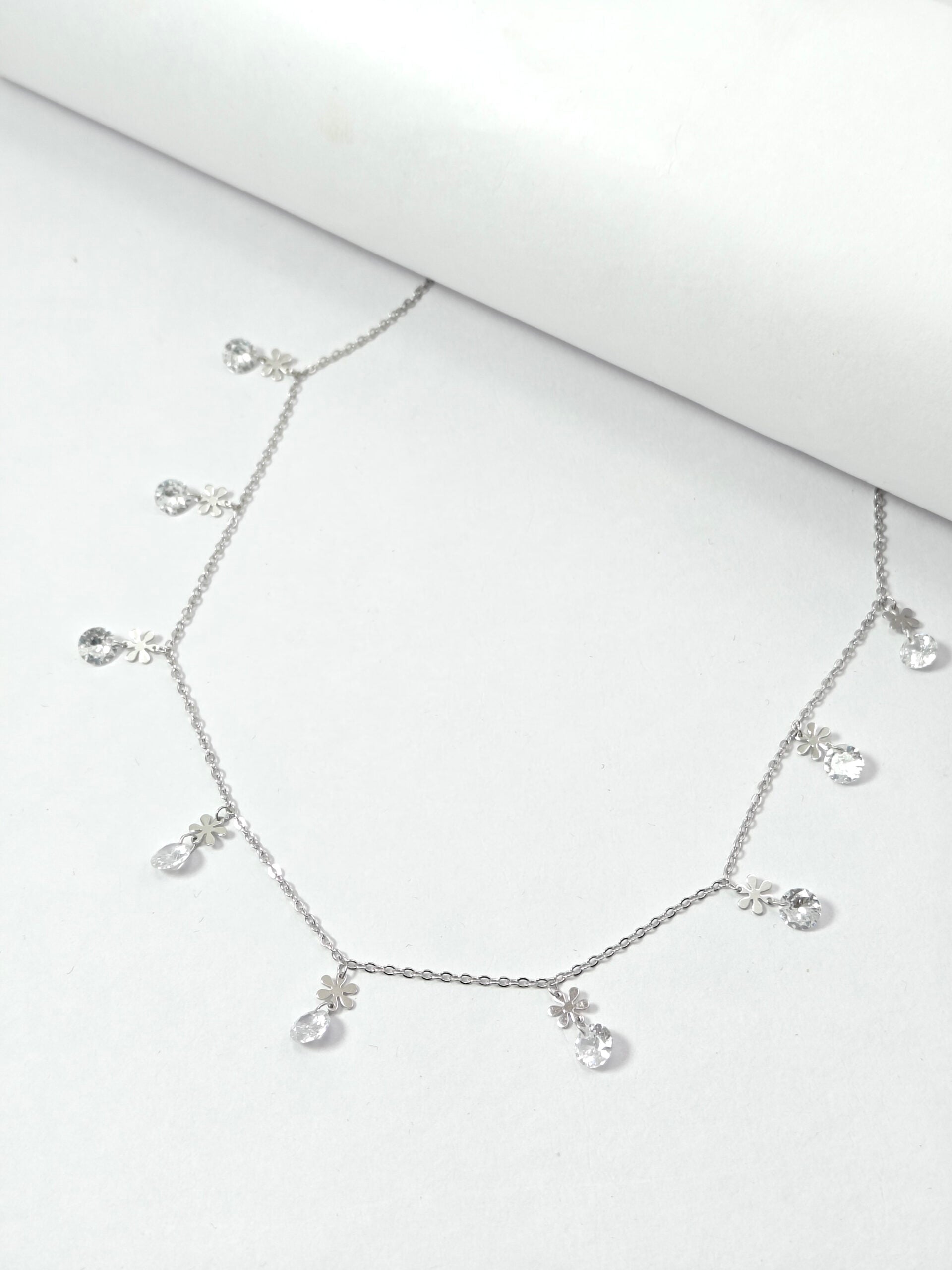 Silver necklace with heart-shaped pendants on a white background