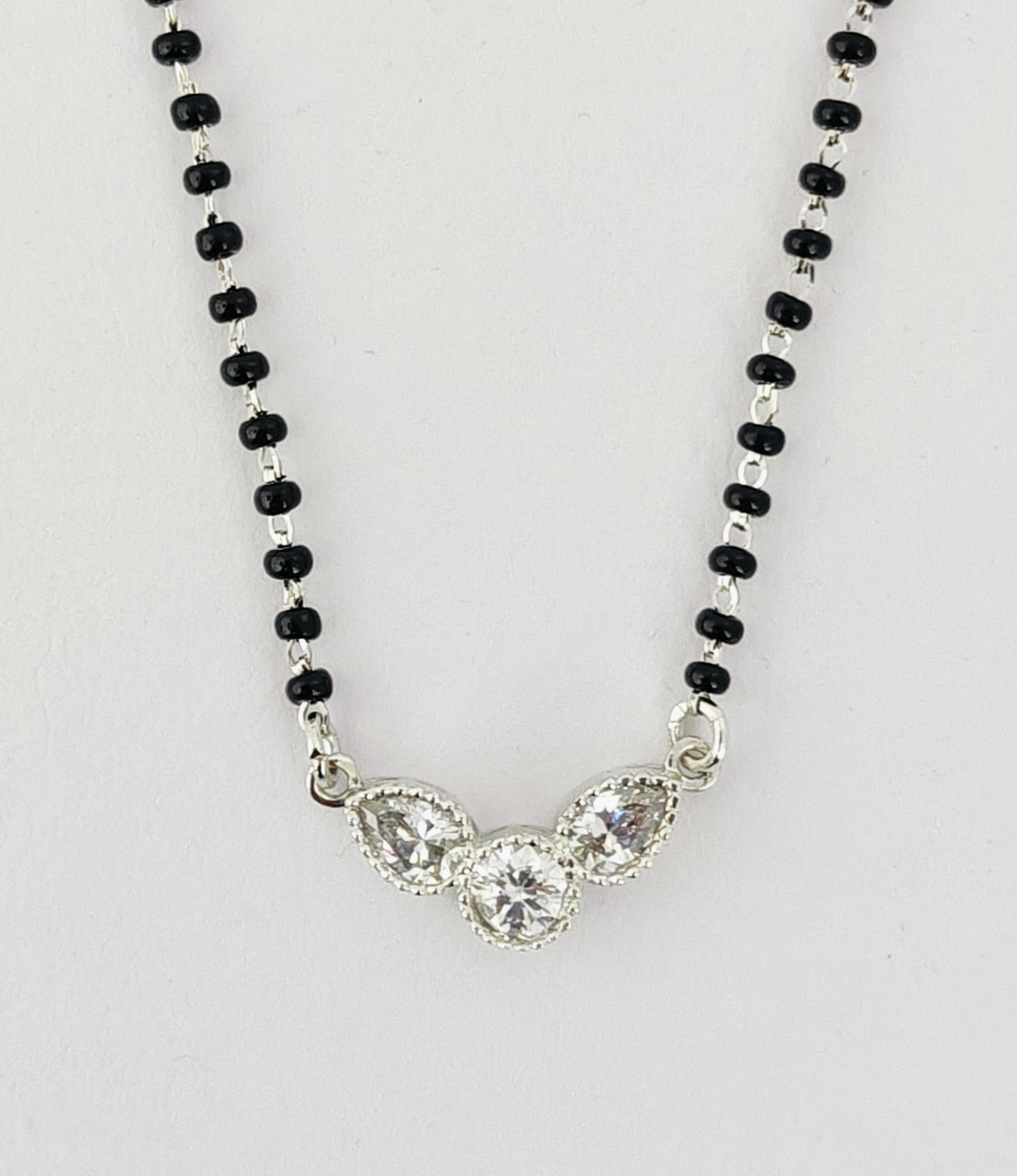 Necklace with black beads and a silver clasp on a white background