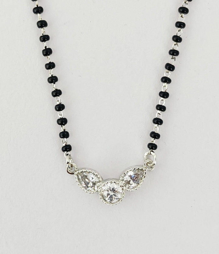Necklace with black beads and a silver clasp on a white background