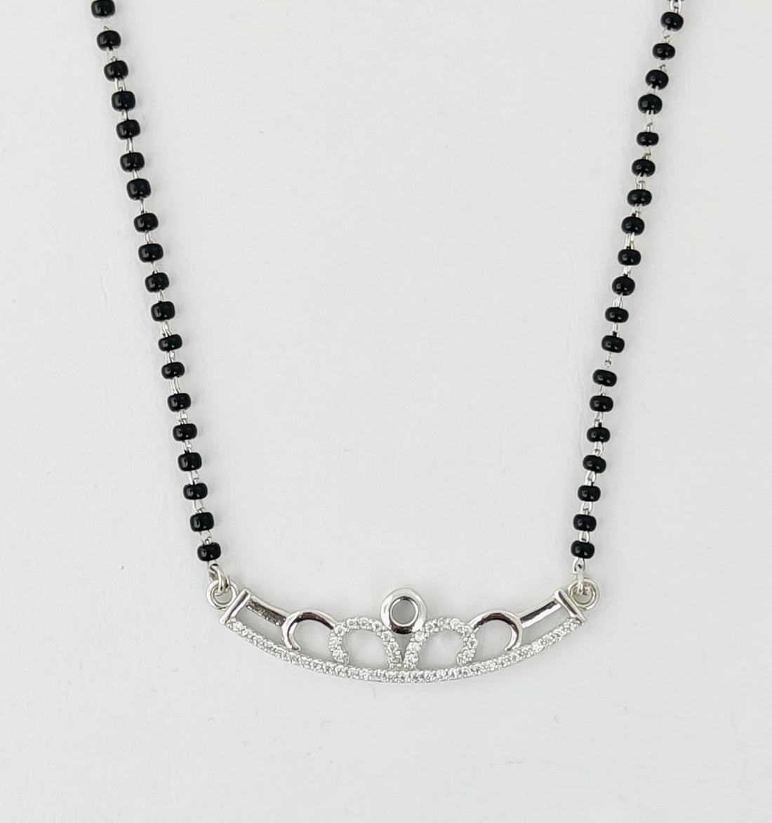 Necklace with black beads and silver clasp on a white background