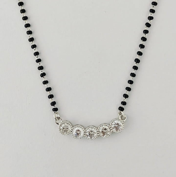 Necklace with black beaded chain and silver clasp on a light gray background