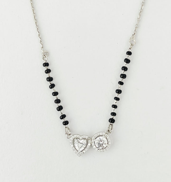 Necklace with heart-shaped pendants and black beads on a light gray background