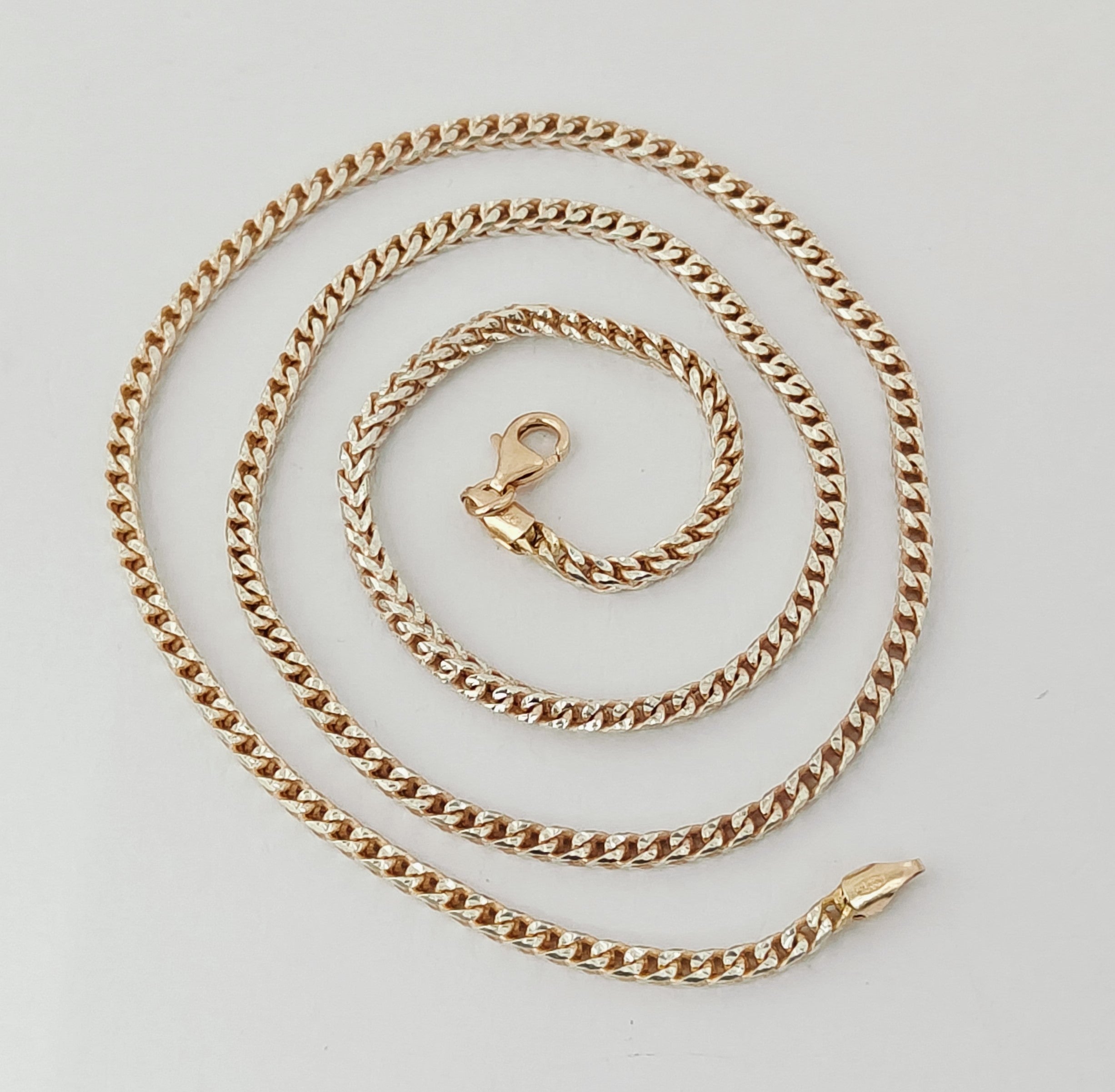 Gold chain necklace on a light gray background