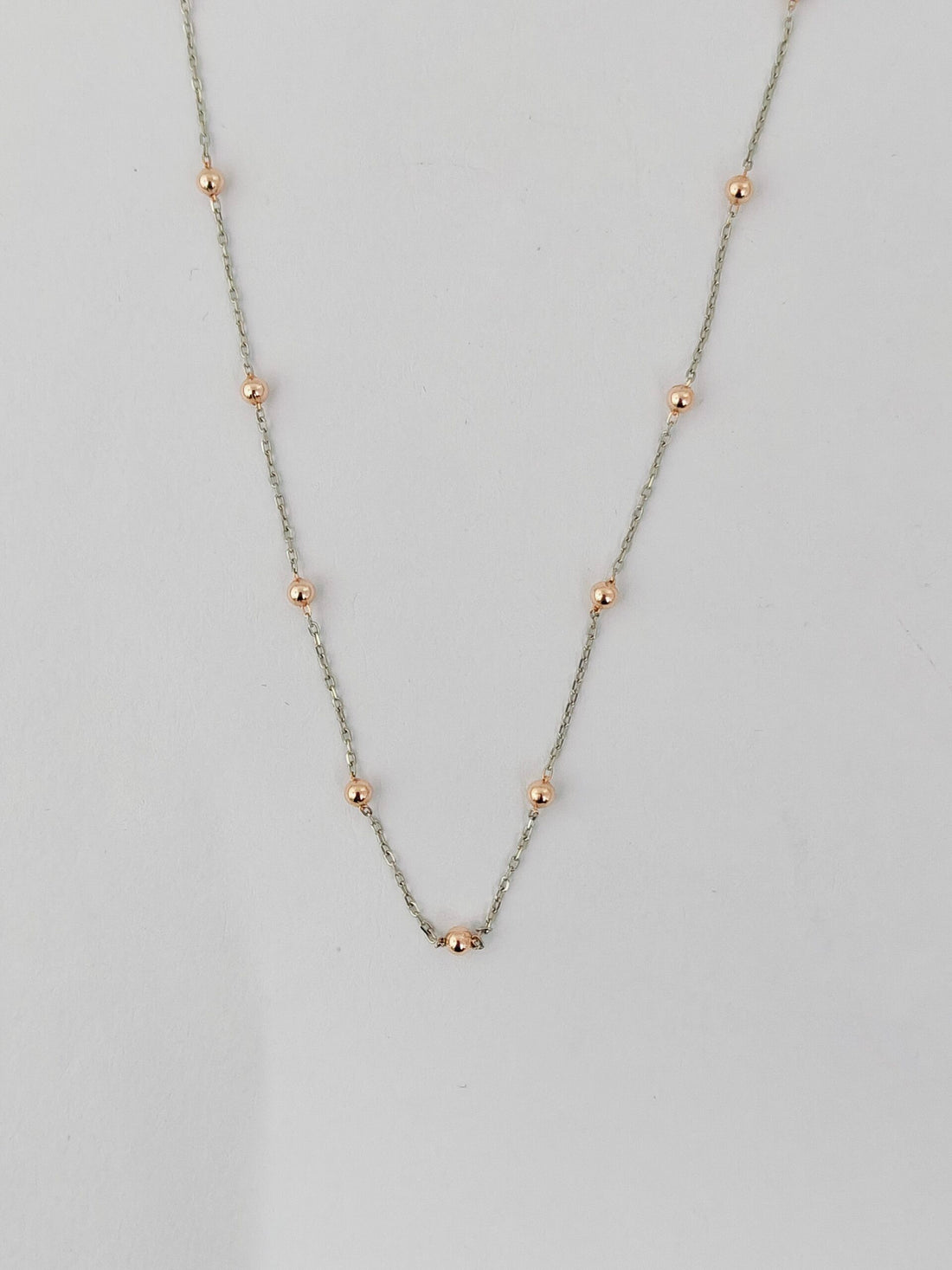 Necklace with small beads on a light gray background