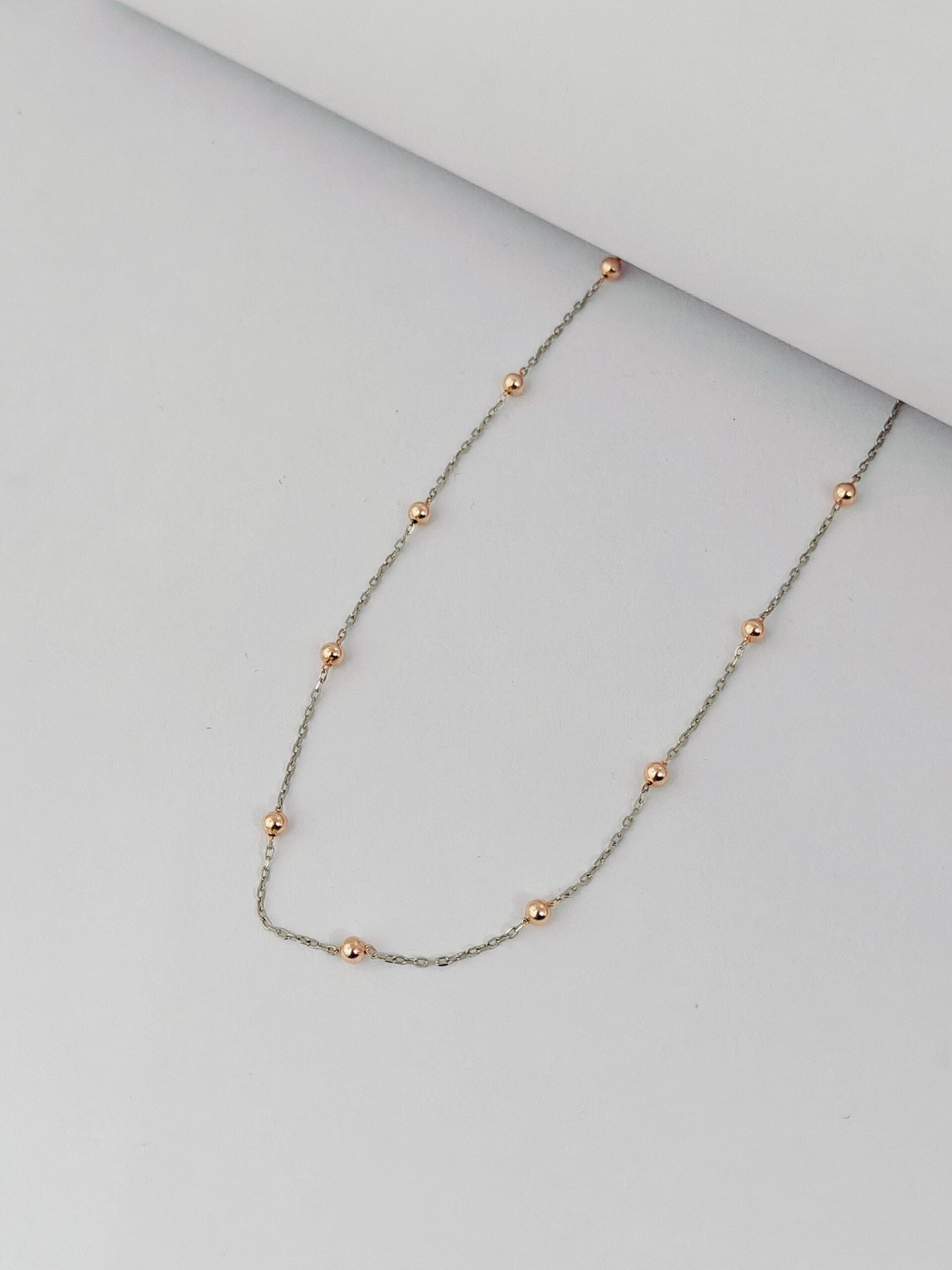 Necklace with small round beads on a light gray background