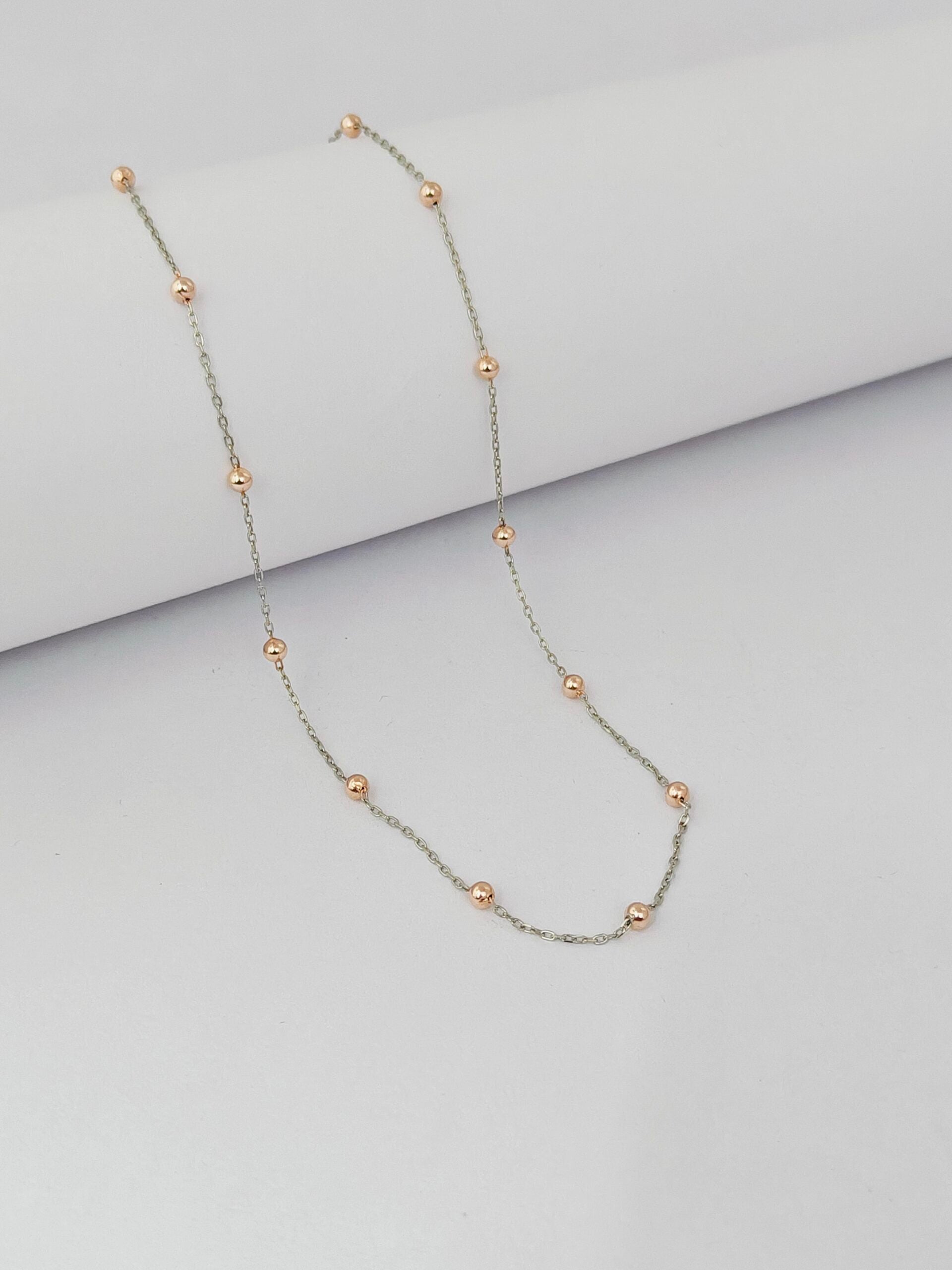 Necklace with small beads on a light gray background