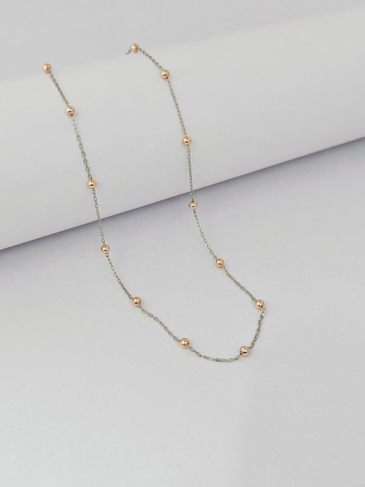 Necklace with small beads on a light gray background