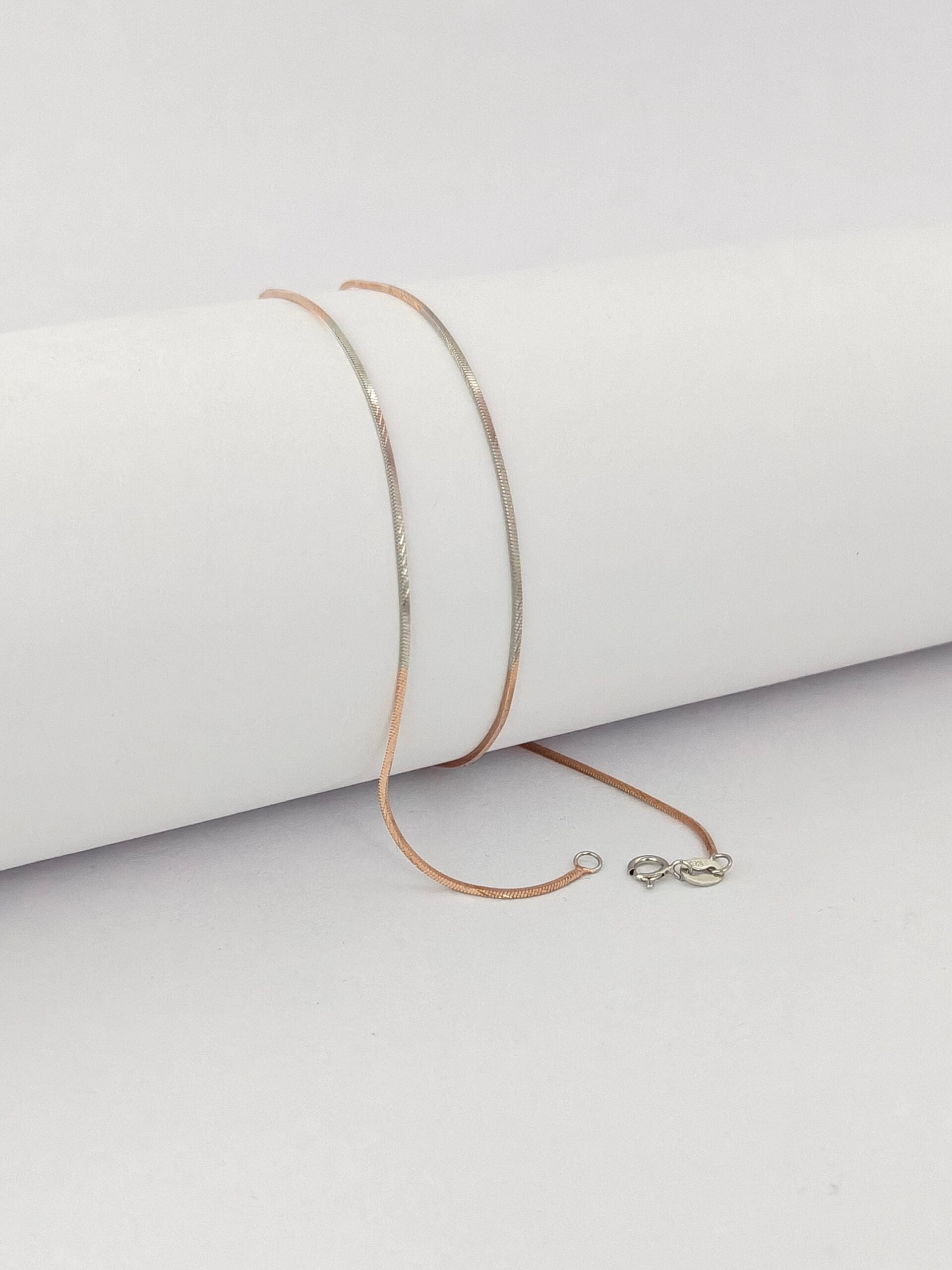 Gold necklace on a white surface