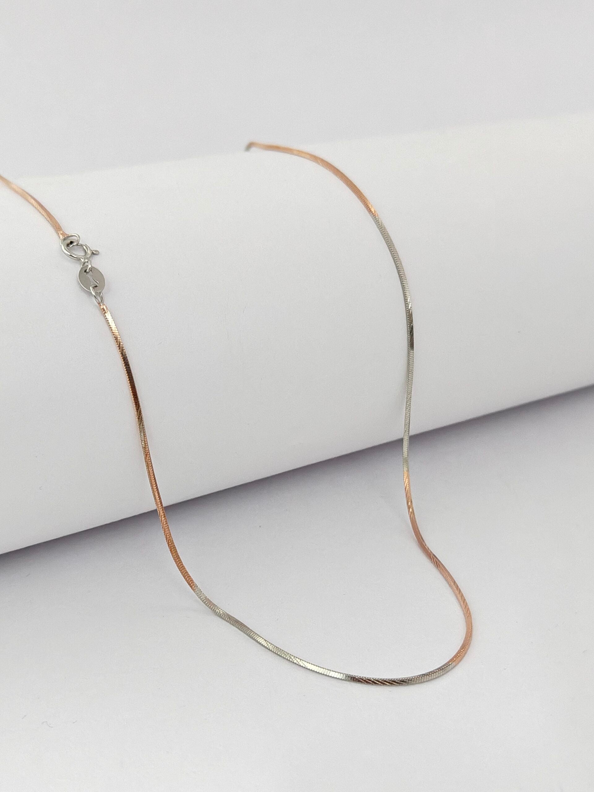 Silver chain necklace on a white surface