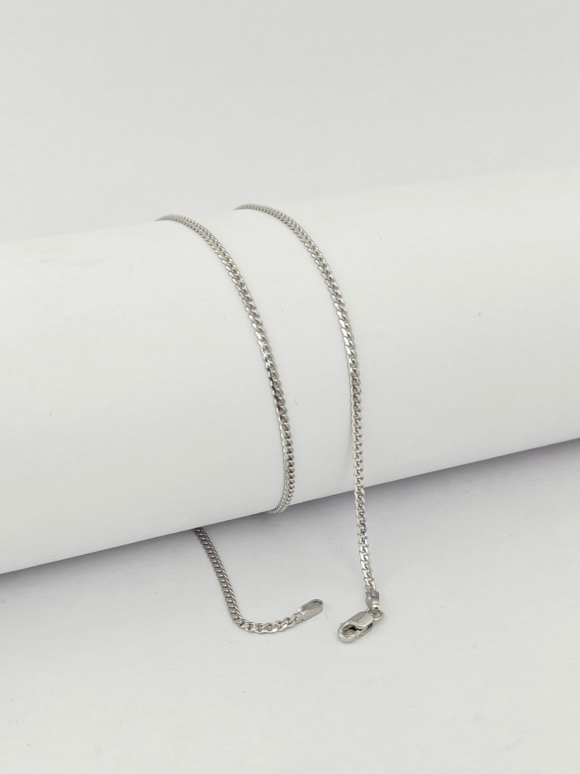 Silver chain necklace on a light gray background