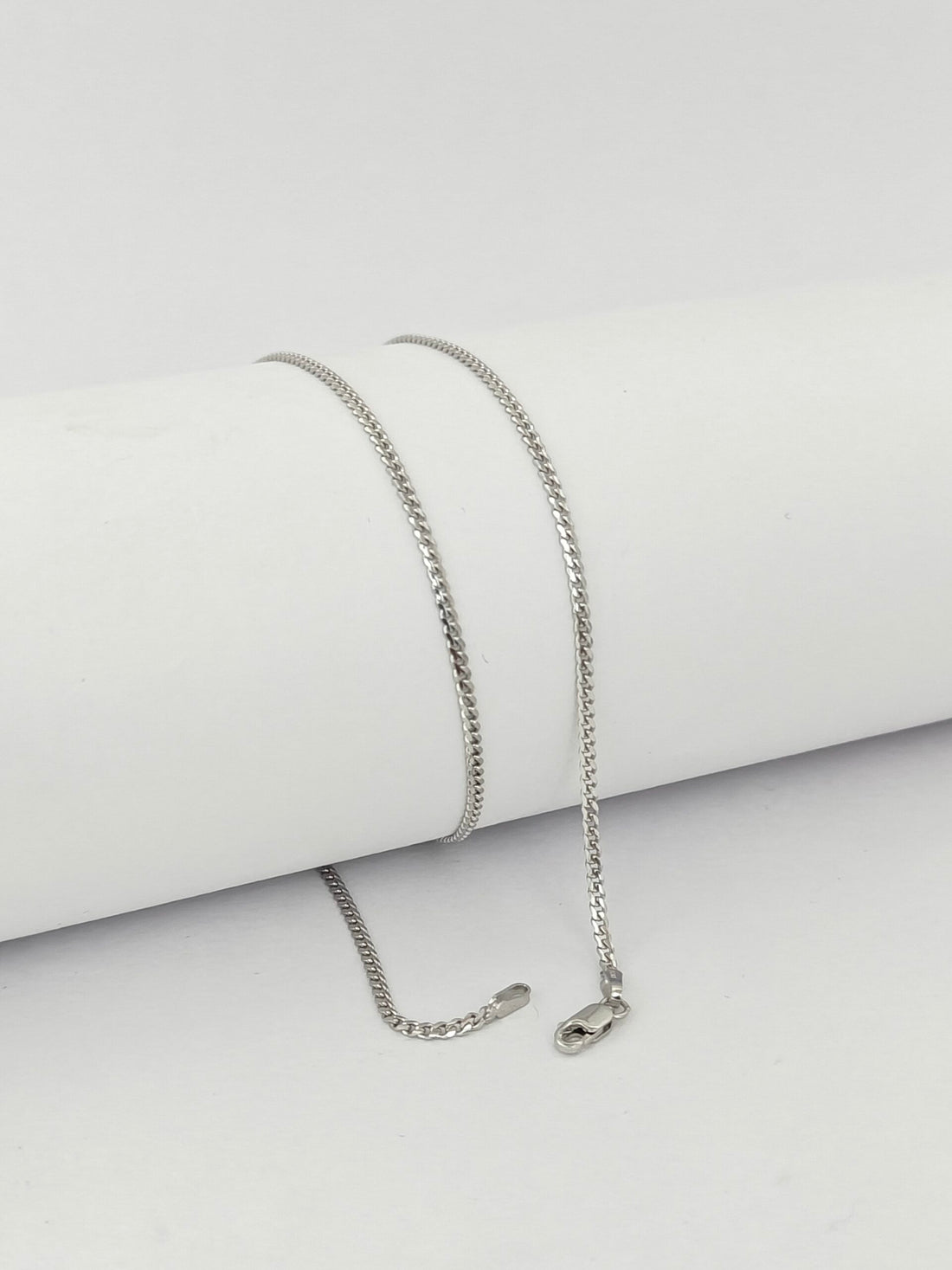 Silver chain necklace on a light gray background