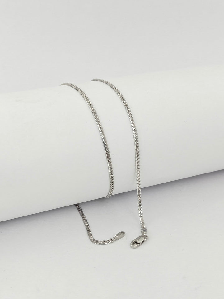 Silver chain necklace on a light gray background