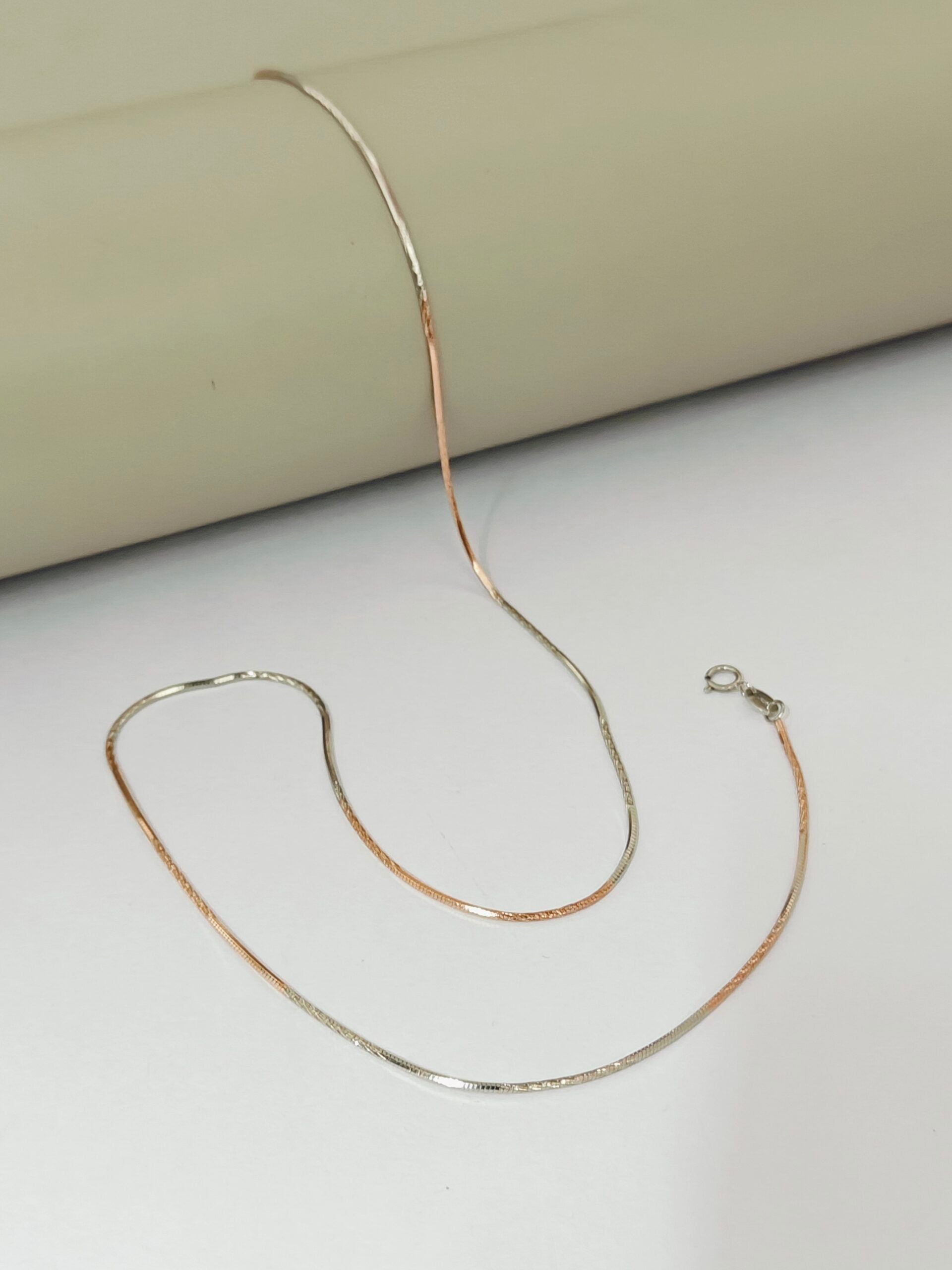 Gold chain necklace on a light background