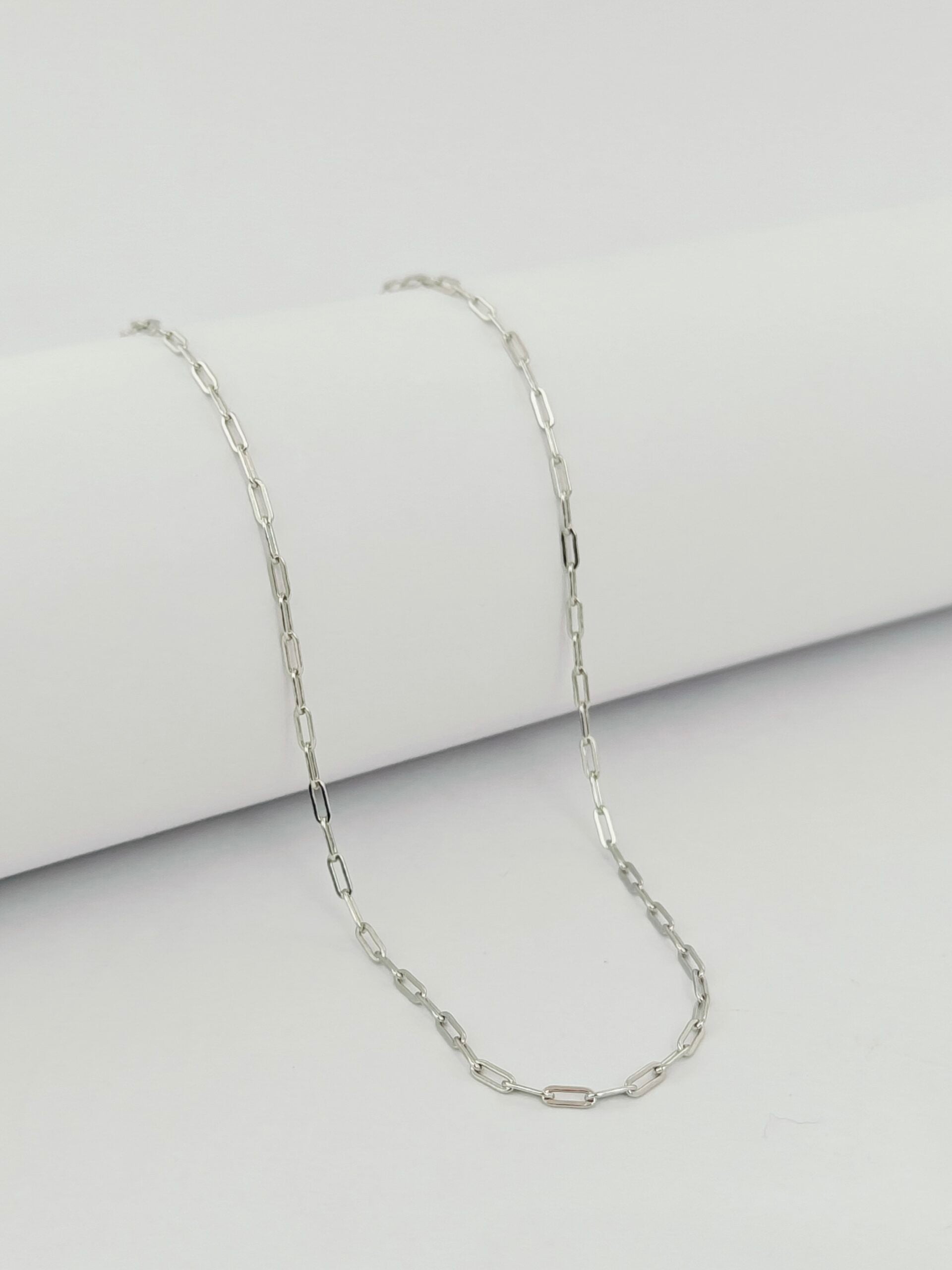 Silver chain necklace on a light gray background