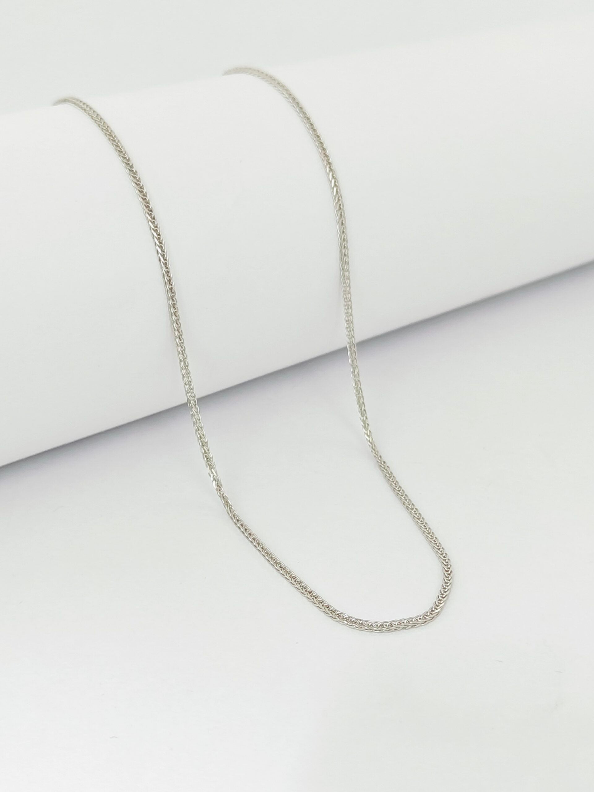 Silver chain necklace on a light gray background