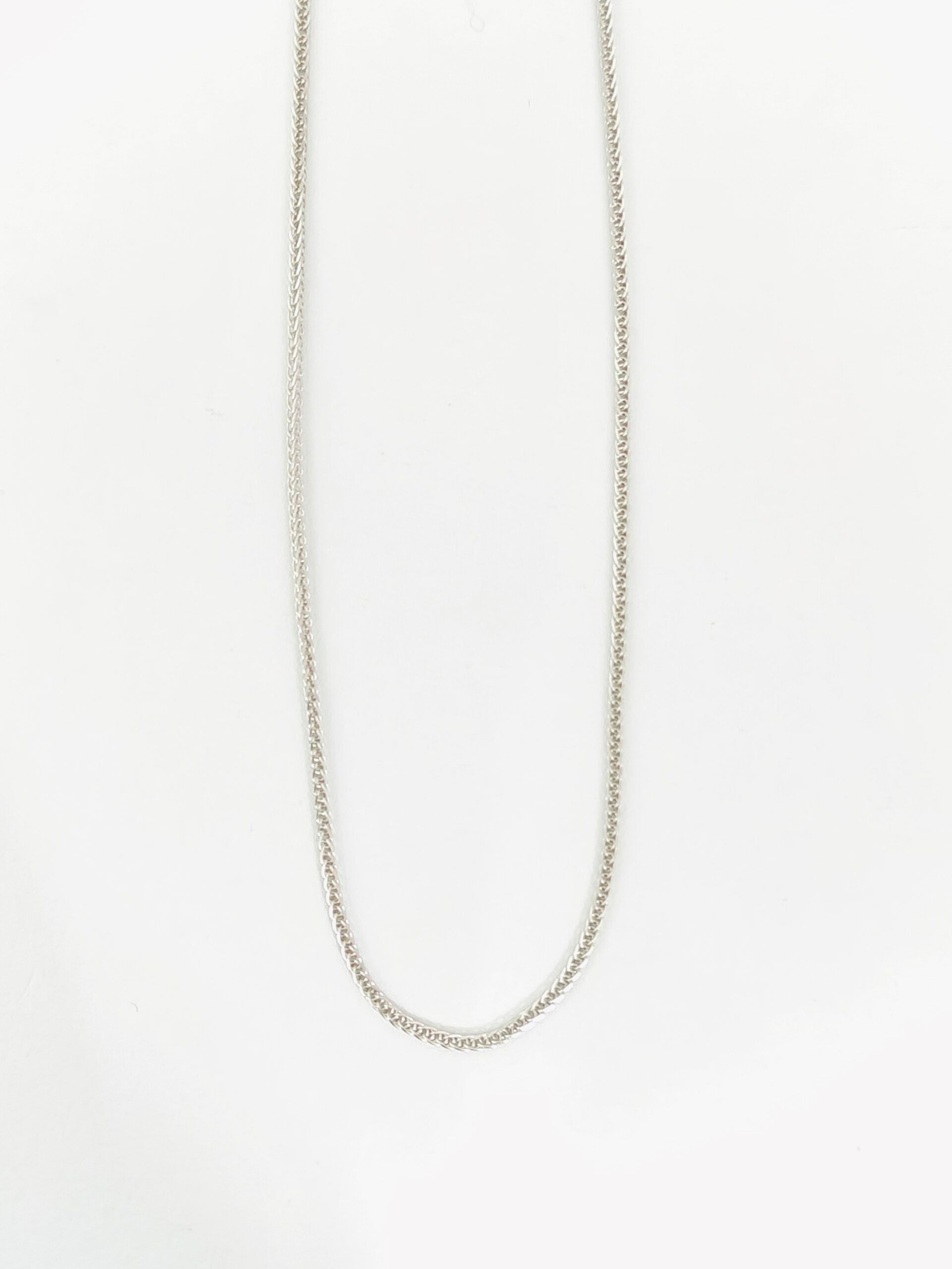 Silver chain necklace on a light gray background