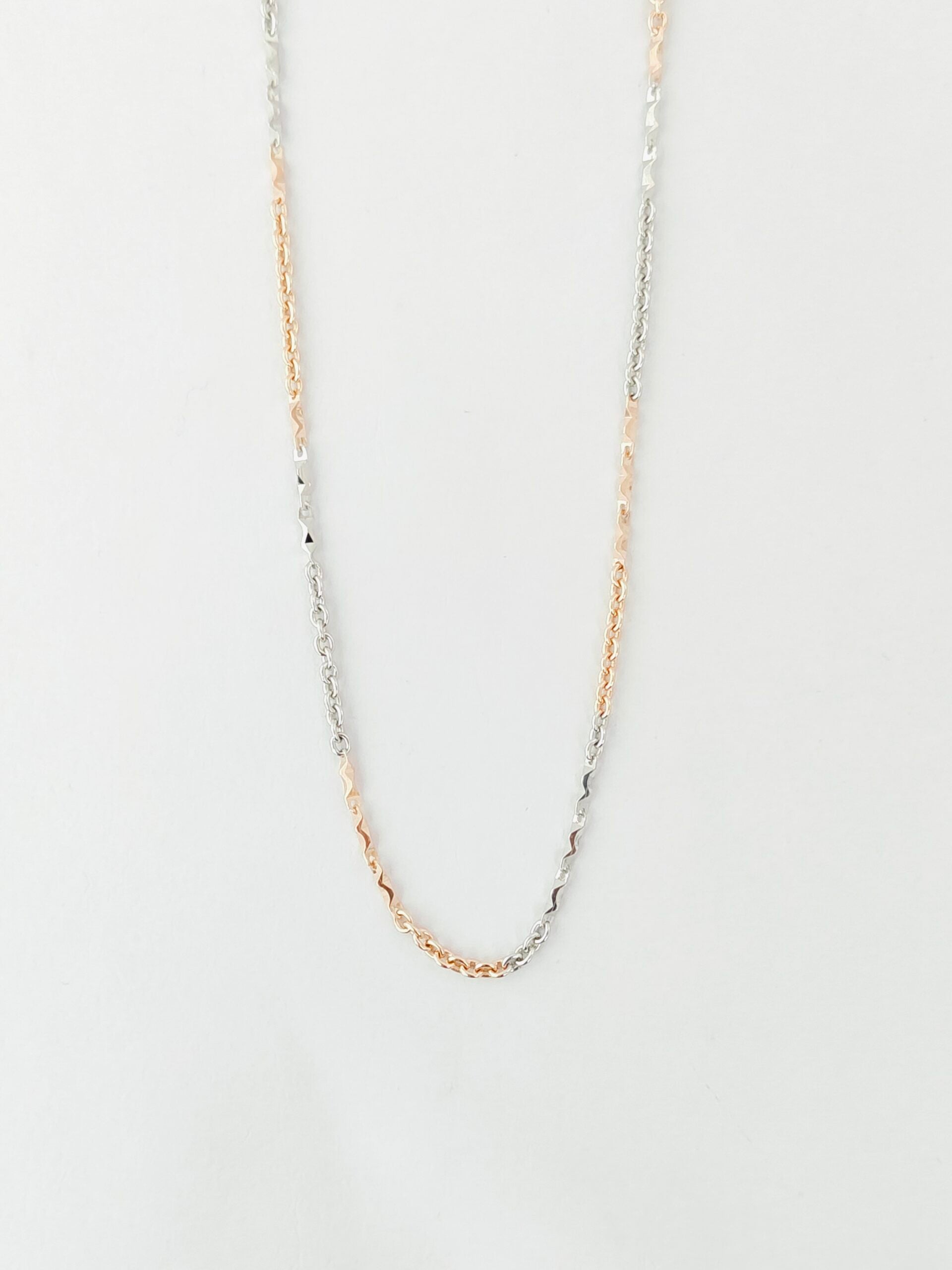 Gold chain necklace on a light gray background