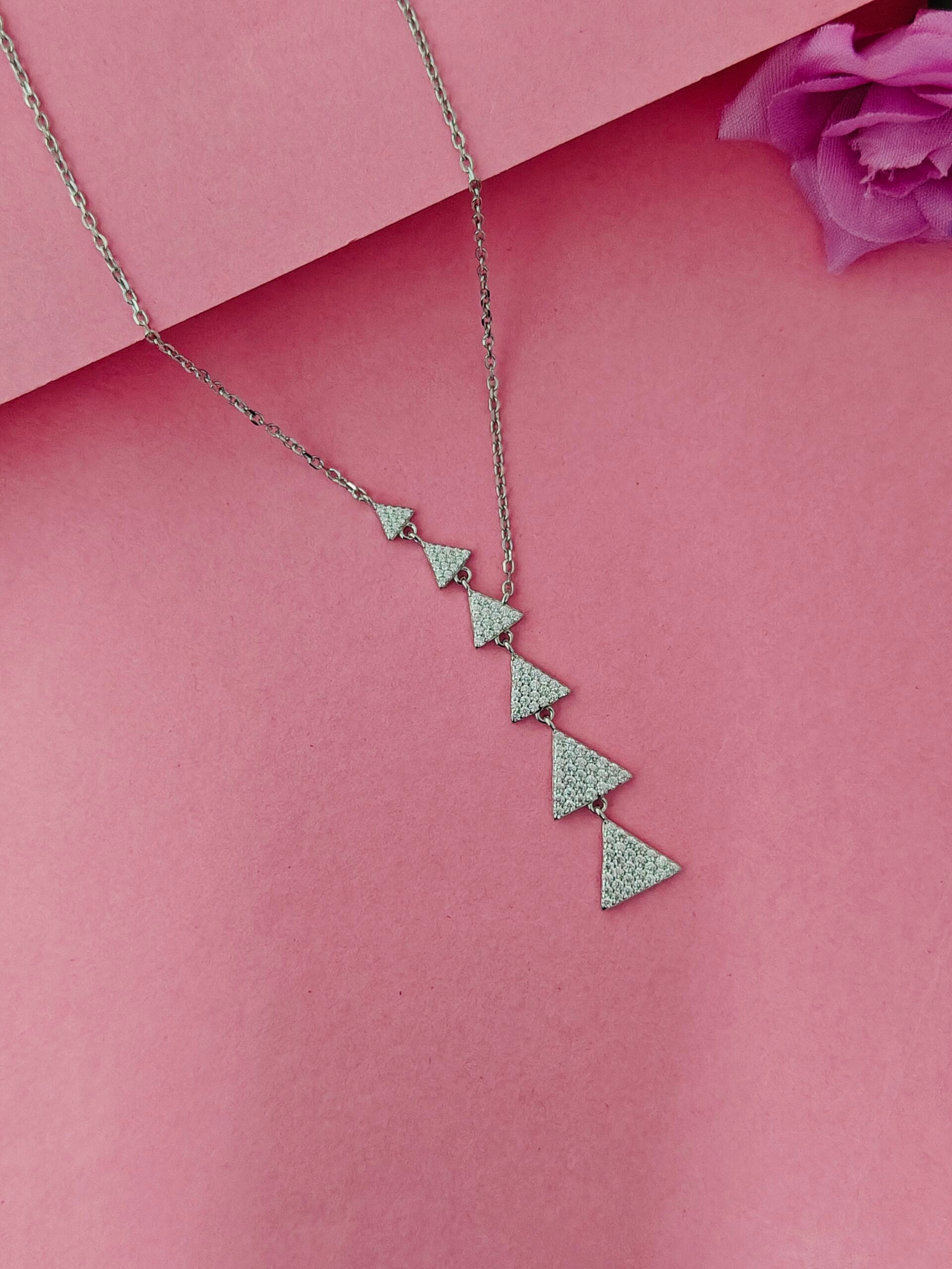 Necklace with triangular pendants on a pink background