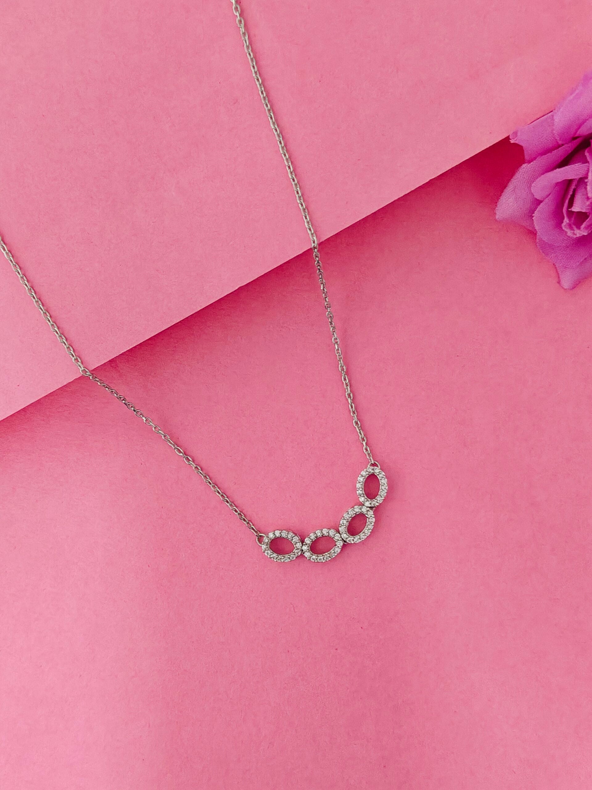 Necklace with a floral pendant on a pink background