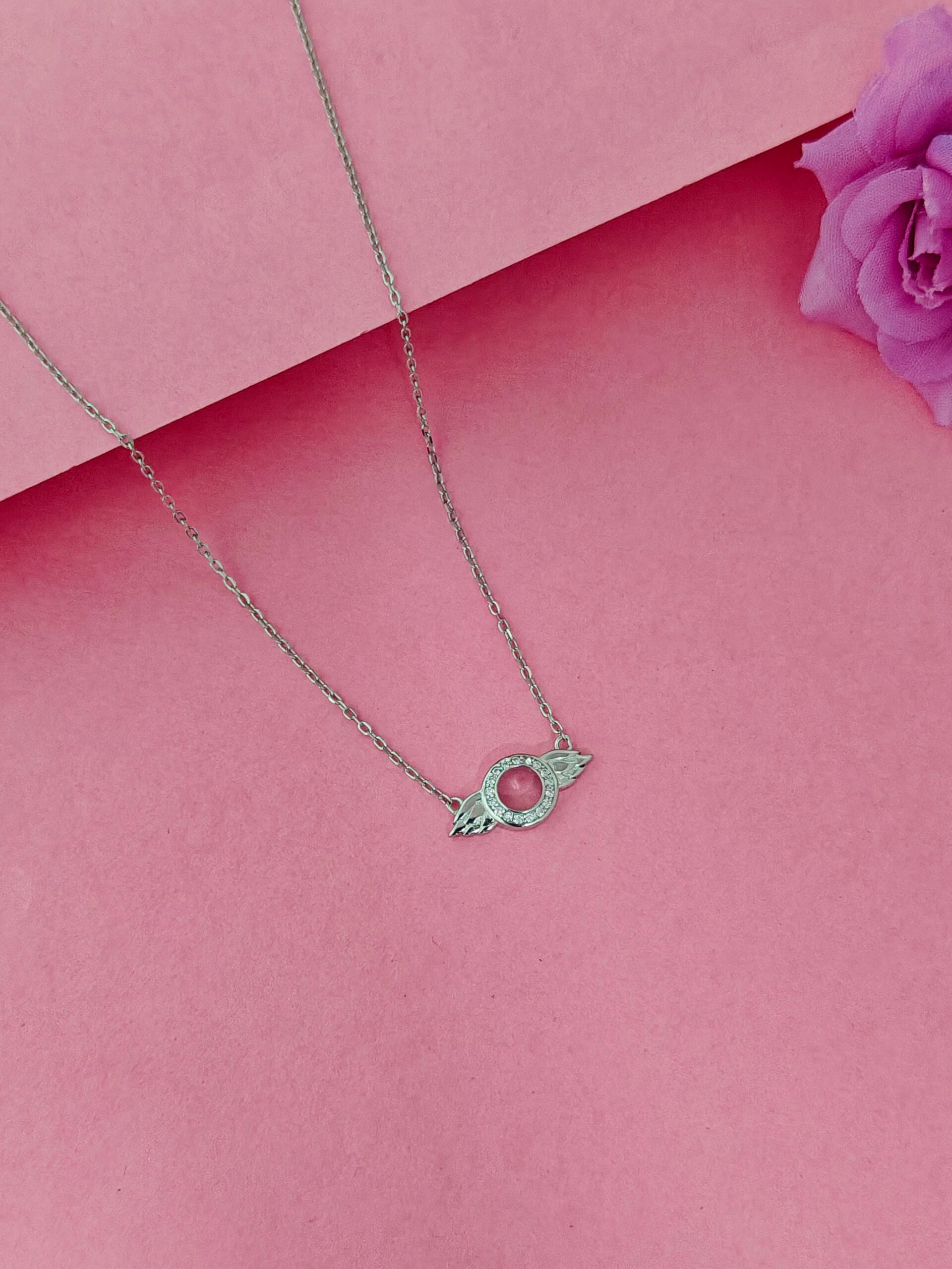 Necklace with a green pendant on a pink background