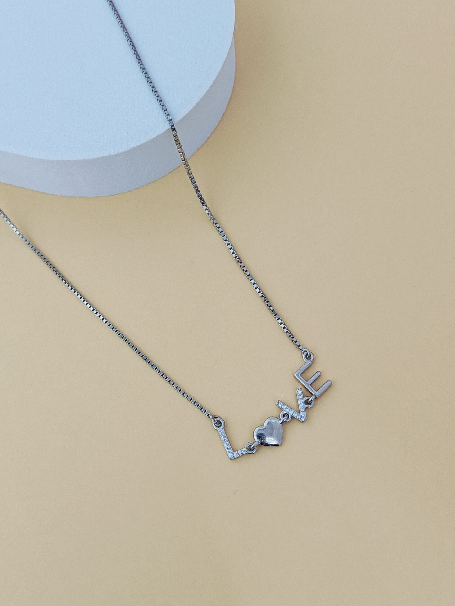 Silver necklace with a unique design on a beige background