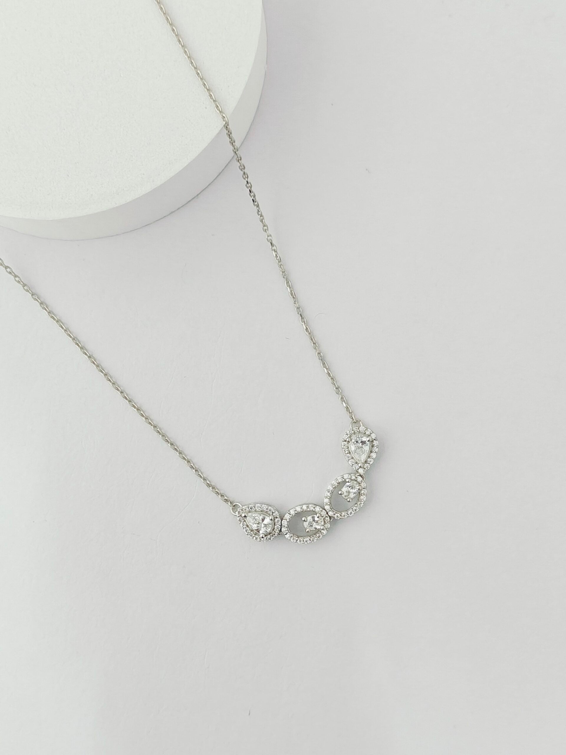 Silver necklace with a floral design on a light gray background