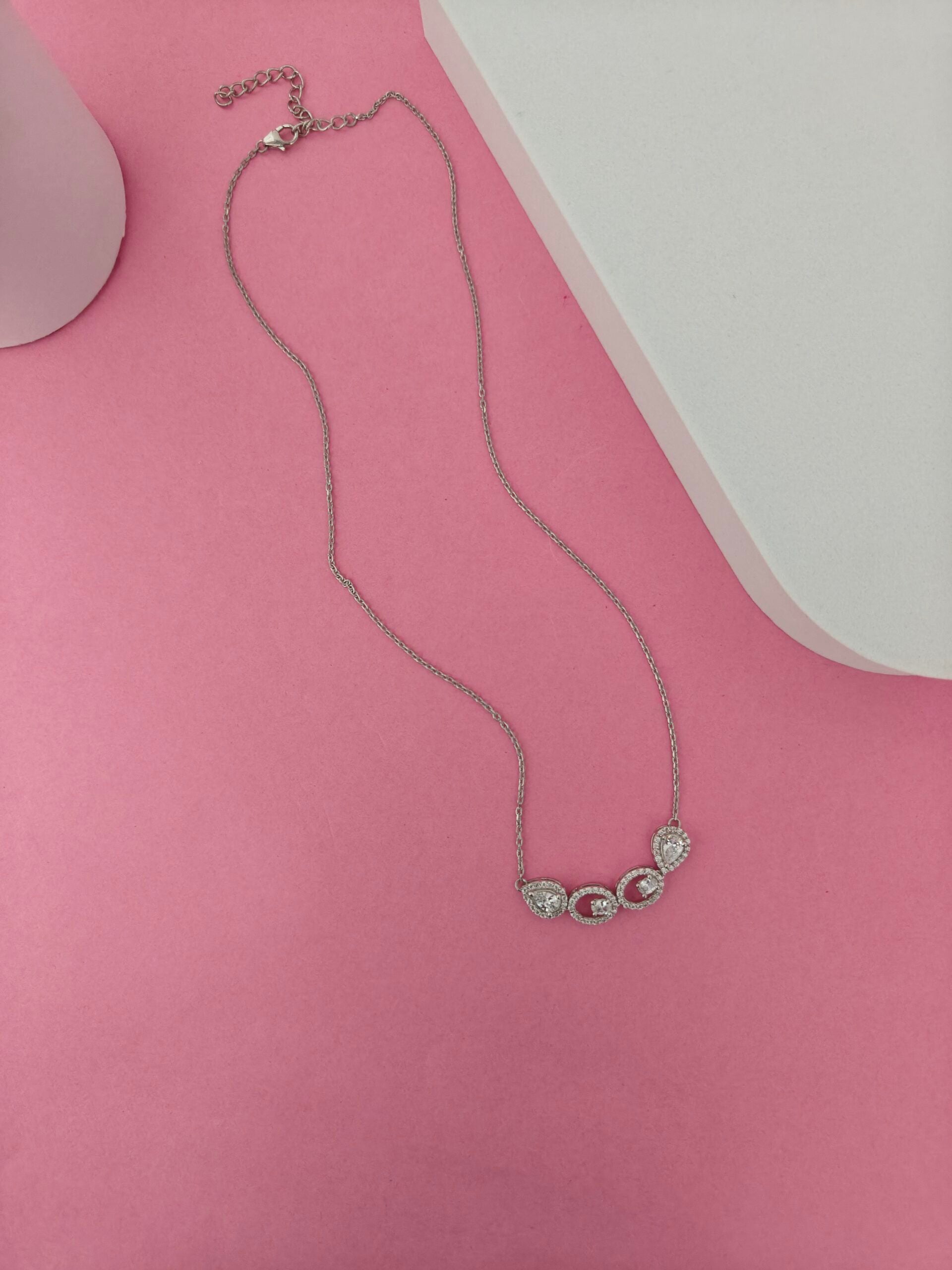 Necklace with heart-shaped pendants on a pink surface