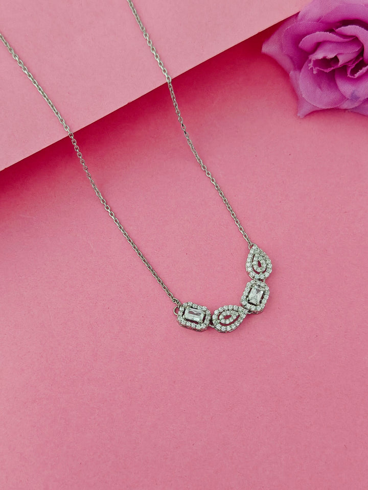 Silver necklace with gemstones on a pink background