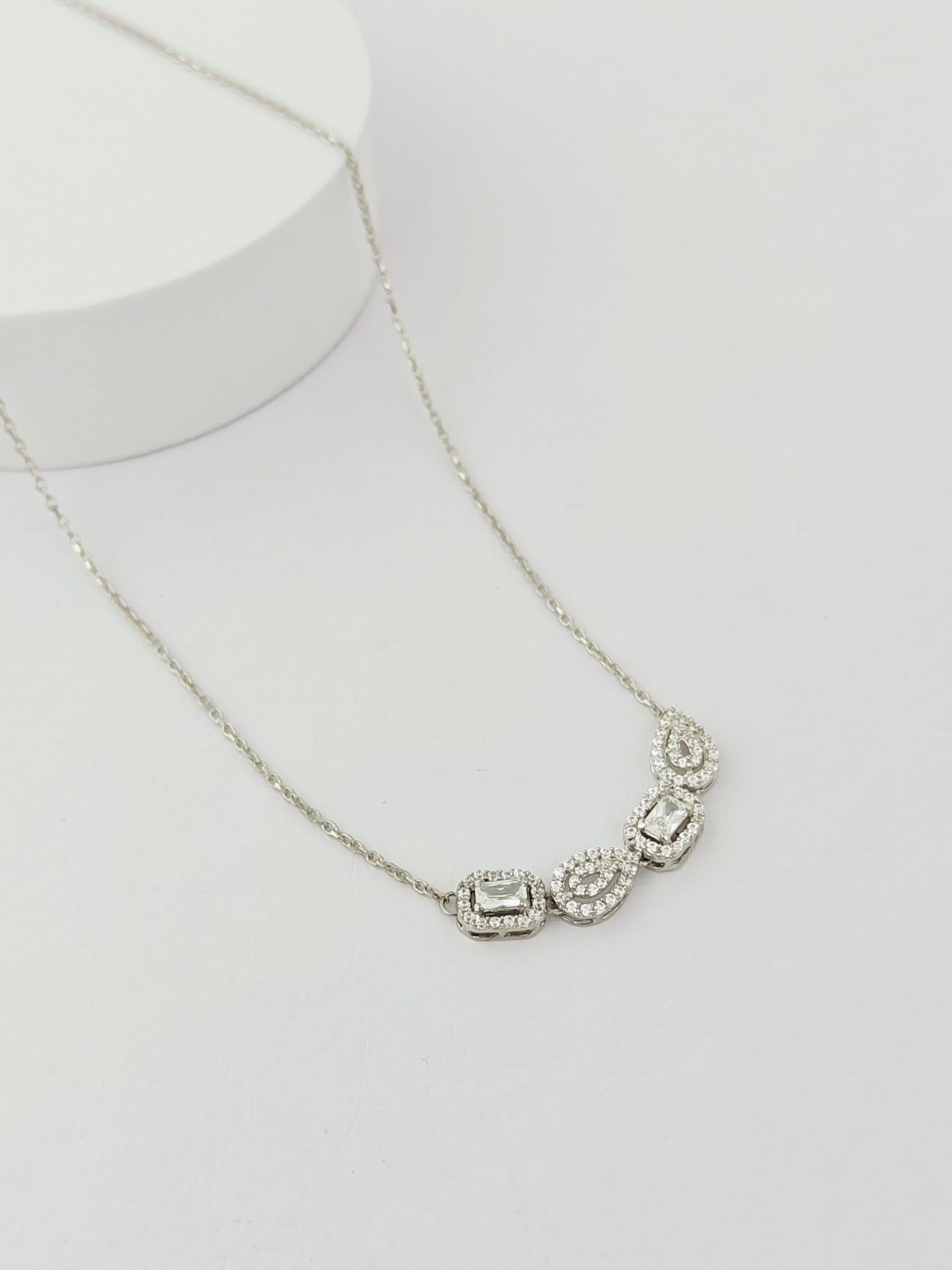 Silver necklace with a pendant on a light gray background