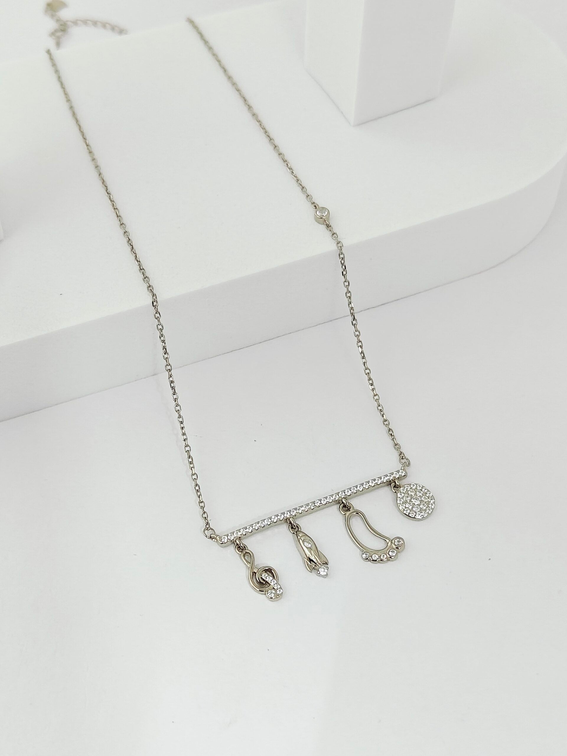 Silver necklace with charms on a white background
