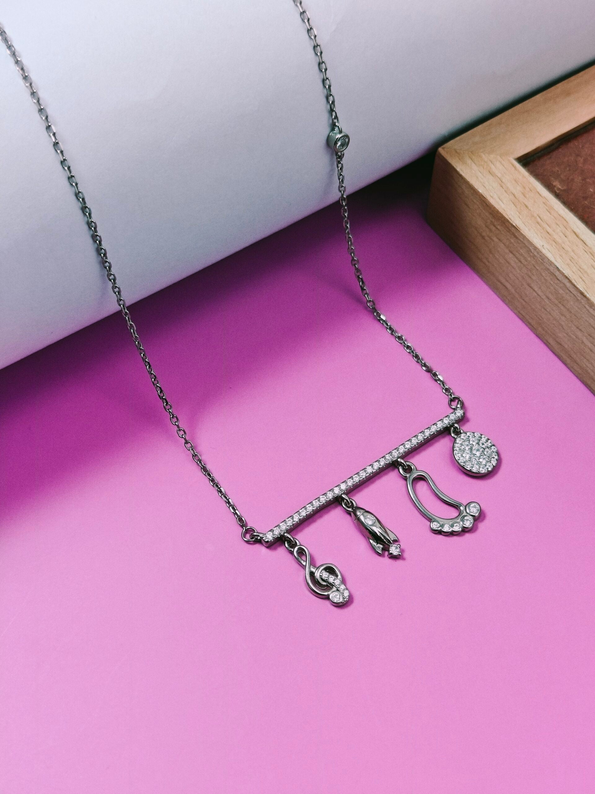 Necklace with charms on a pink surface