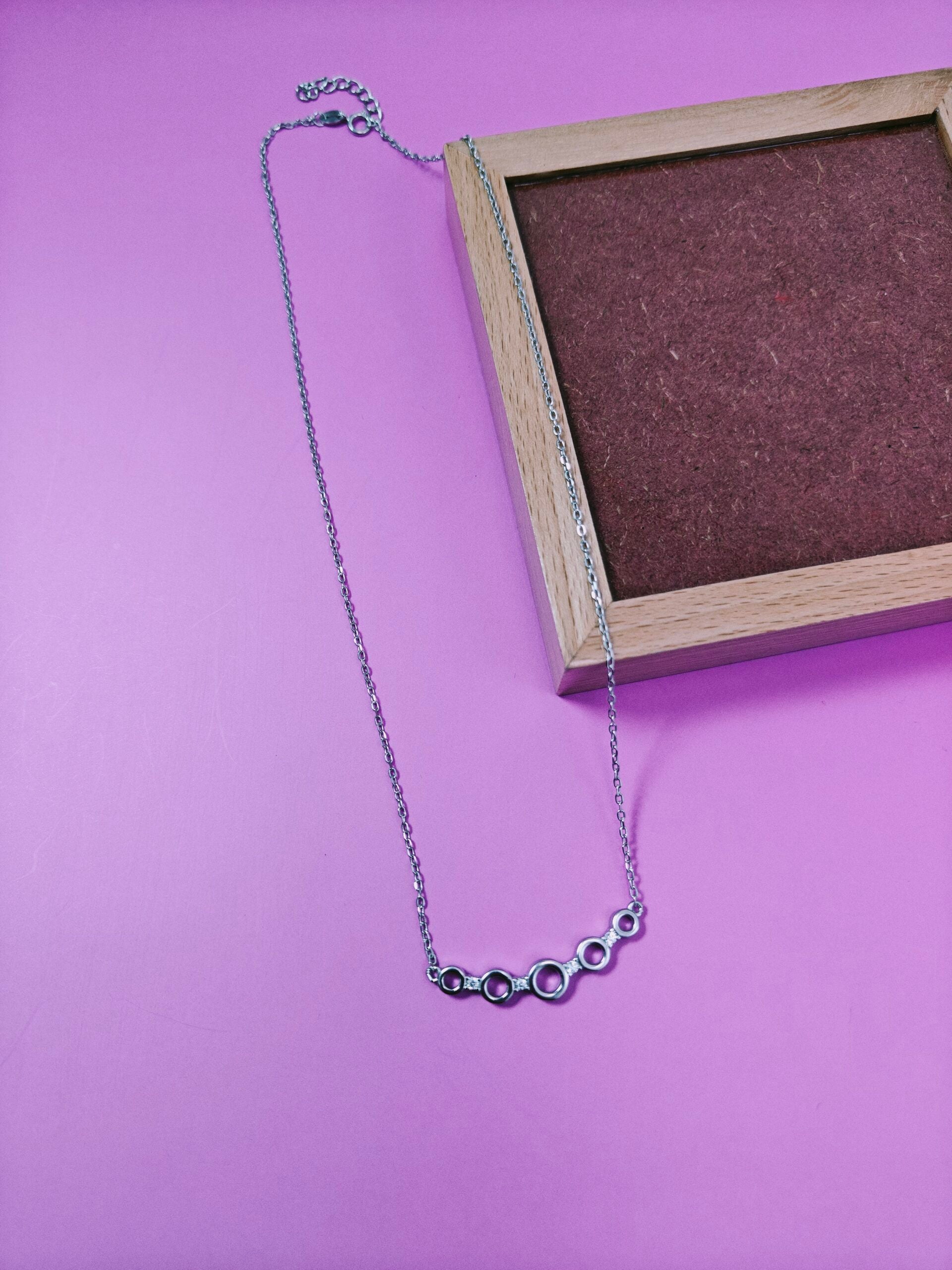 Silver necklace on a pink background